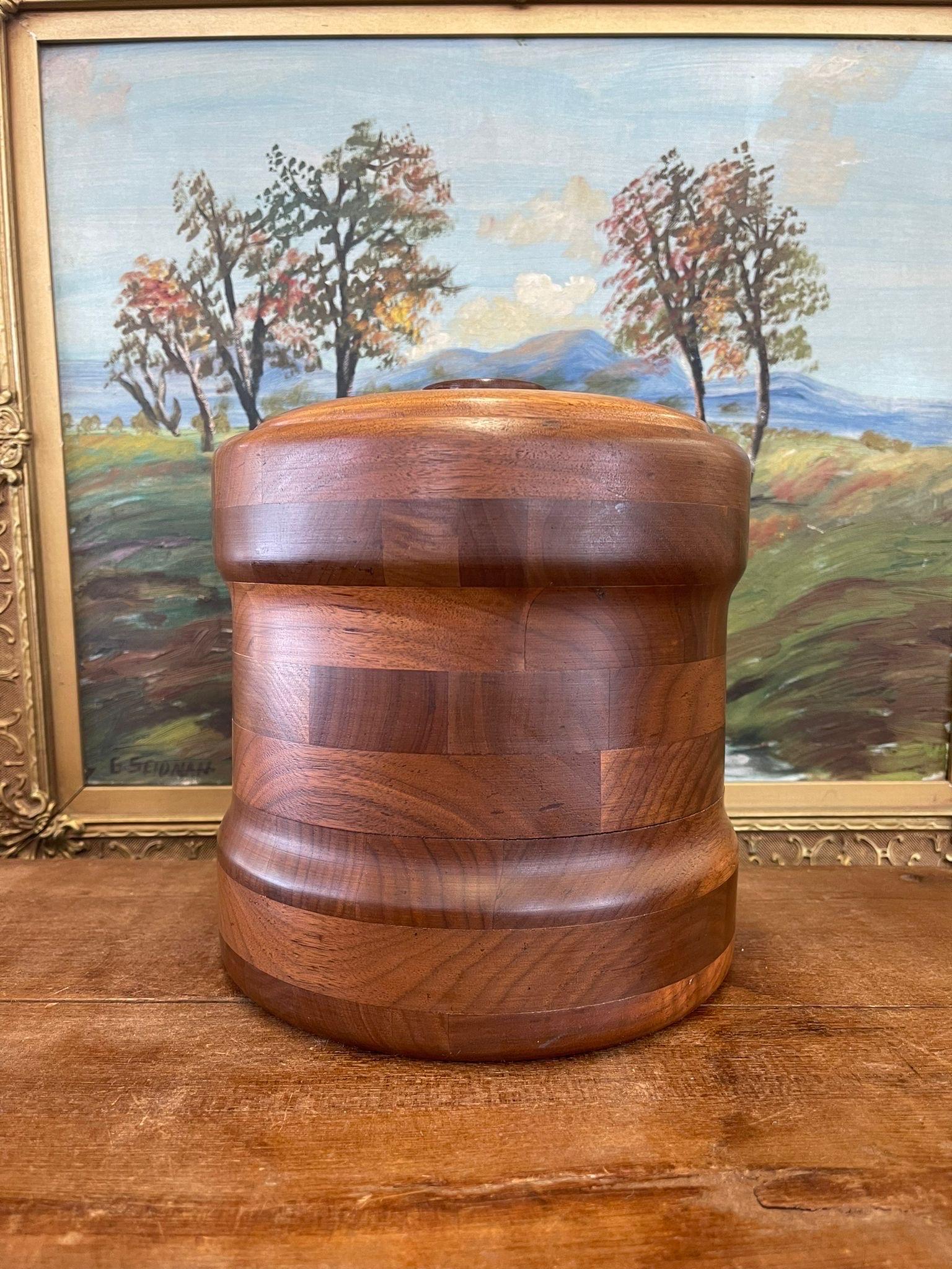 Circa 1960s. Solid Walnut lid and casing, as stated on the markers mark on the bottom. Contrasting wood grains cover the sides. Turned wood Handle. Vintage condition consistent with age as Pictured.

Dimensions. 8 Diameter ; 9 H