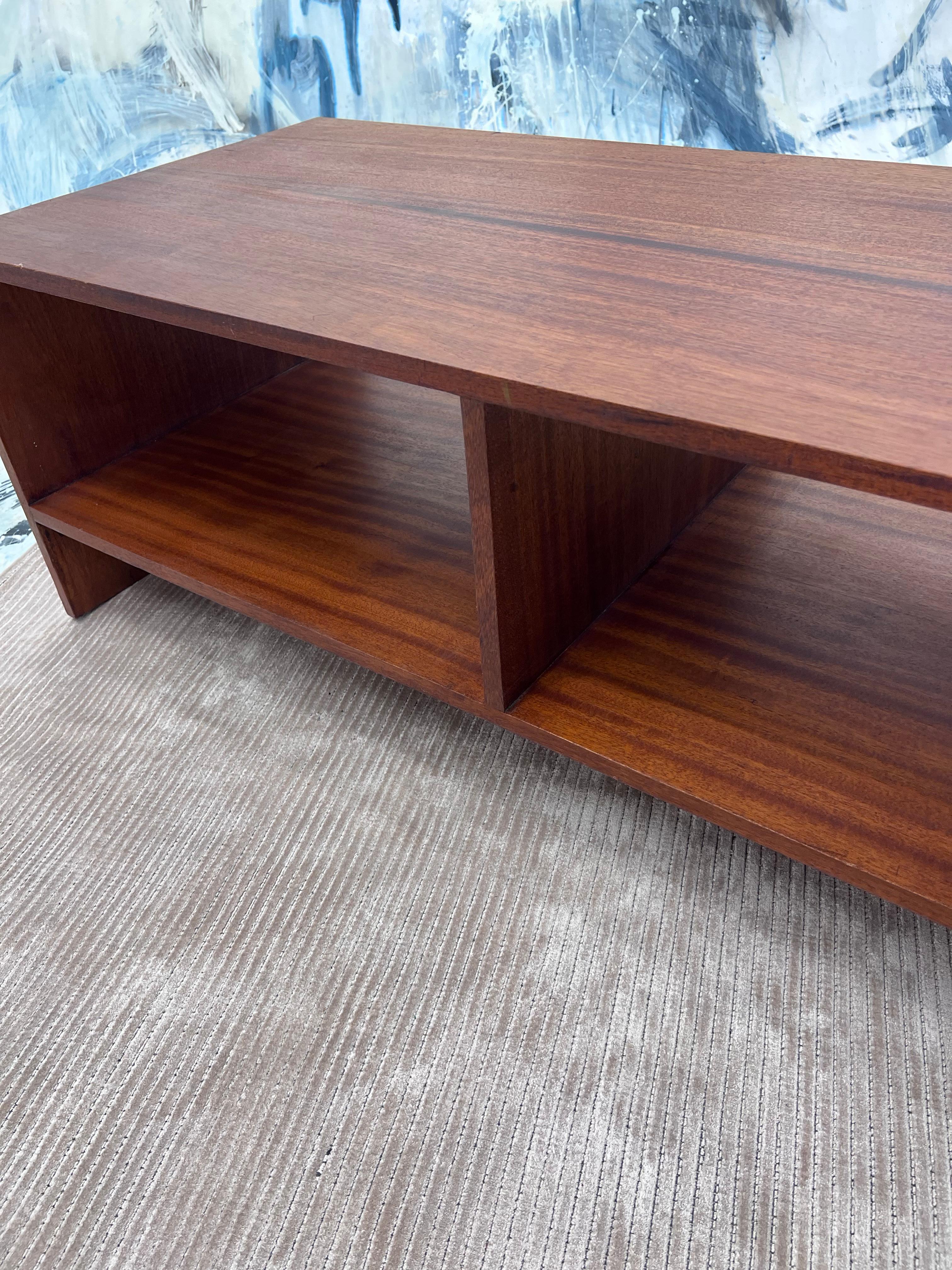Crafted in solid ribbon mahogany the top and sides are made from the same slabs.
Table features intersecting woodworking joinery and waterfall edges. 

Two lower compartments at 10.5” H x 25”L and 22.5”D 
