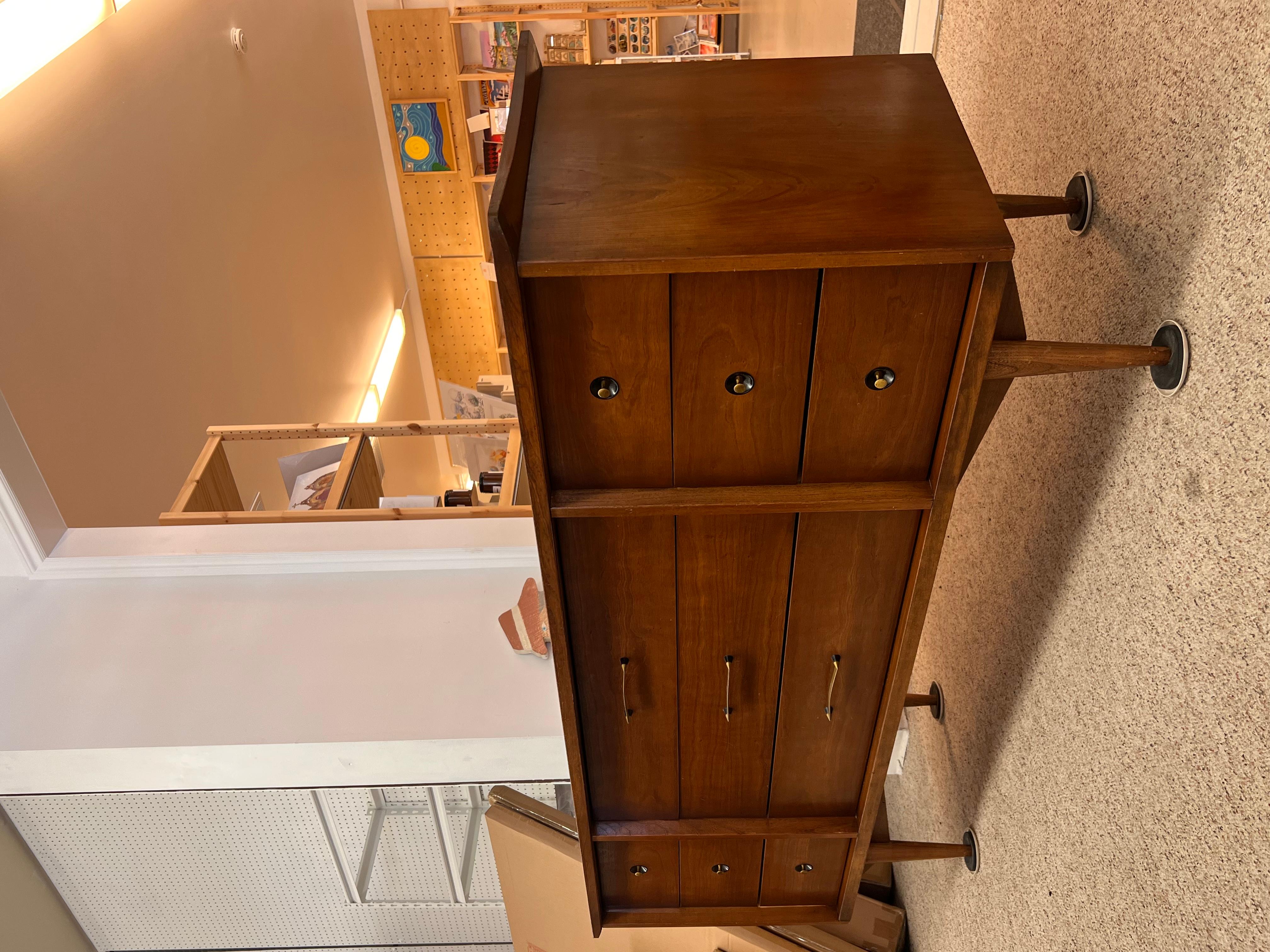 Superbe commode triple moderne du milieu du siècle. Neuf tiroirs offrent de nombreuses possibilités de rangement. Matériel d'origine avec des éléments de conception de l'âge atomique. La surface supérieure a un profil en nœud papillon. Les tiroirs