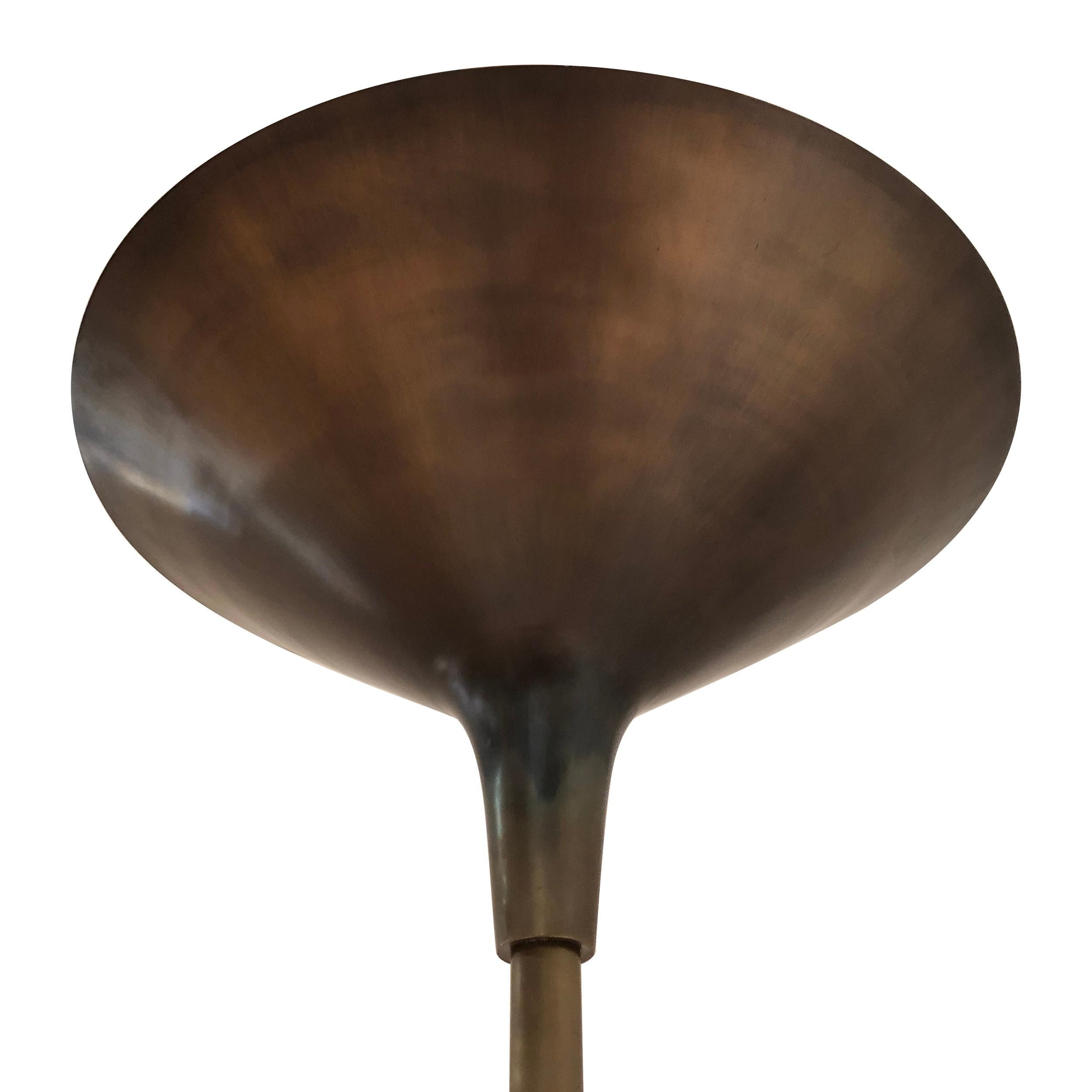 A Scandinavian Modern spun brass torchiere with a flared lamp shade on a disc base. Manufactured in Denmark in the 1960s.