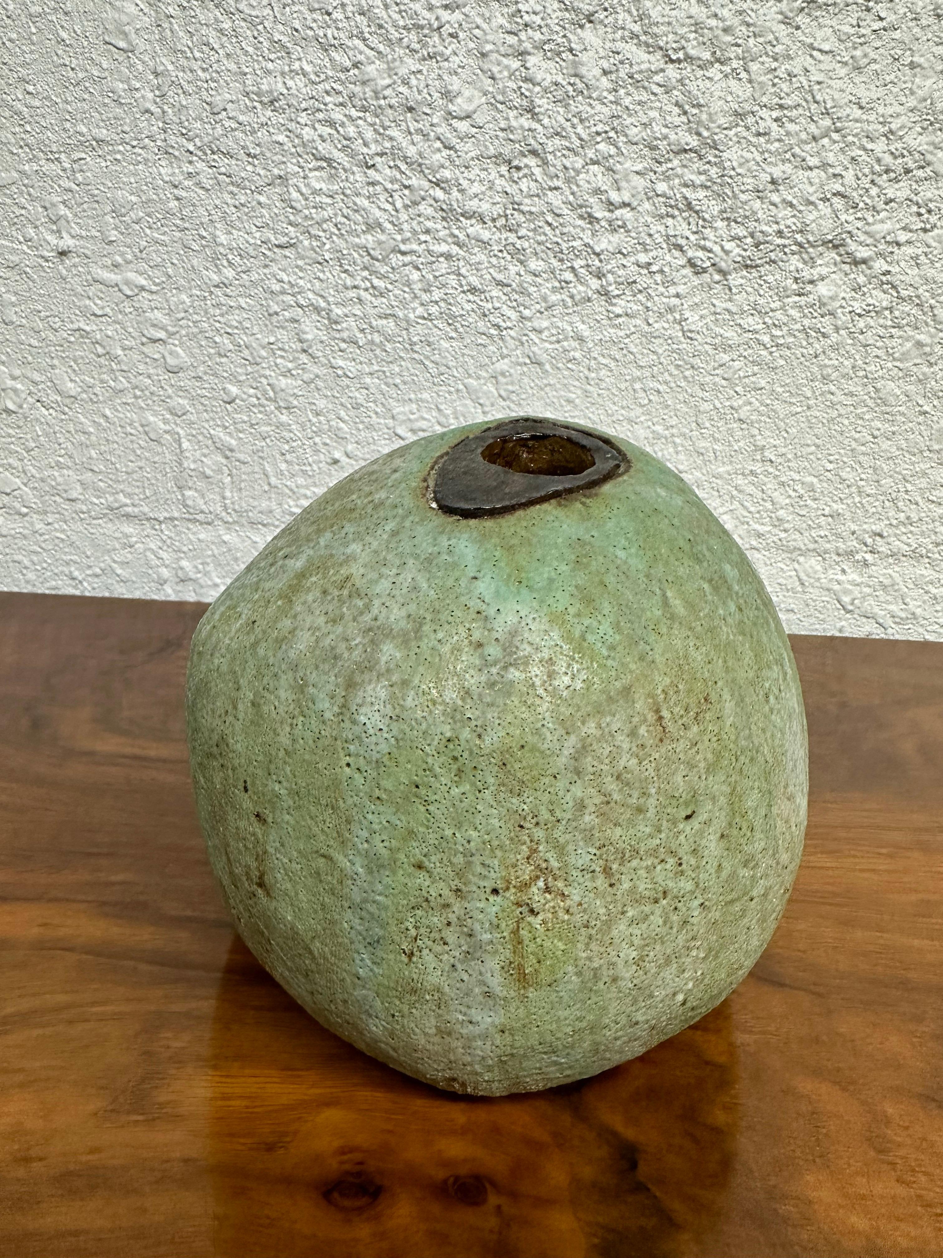 Vintage Mid Century asymmetrical sea foam blue ball vase or weed pot. Great texture and dimension in the glaze with varying shades of sea foam and light blue, with deep brown glossy glazed rim to the small mouth opening on top. Vase is signed on