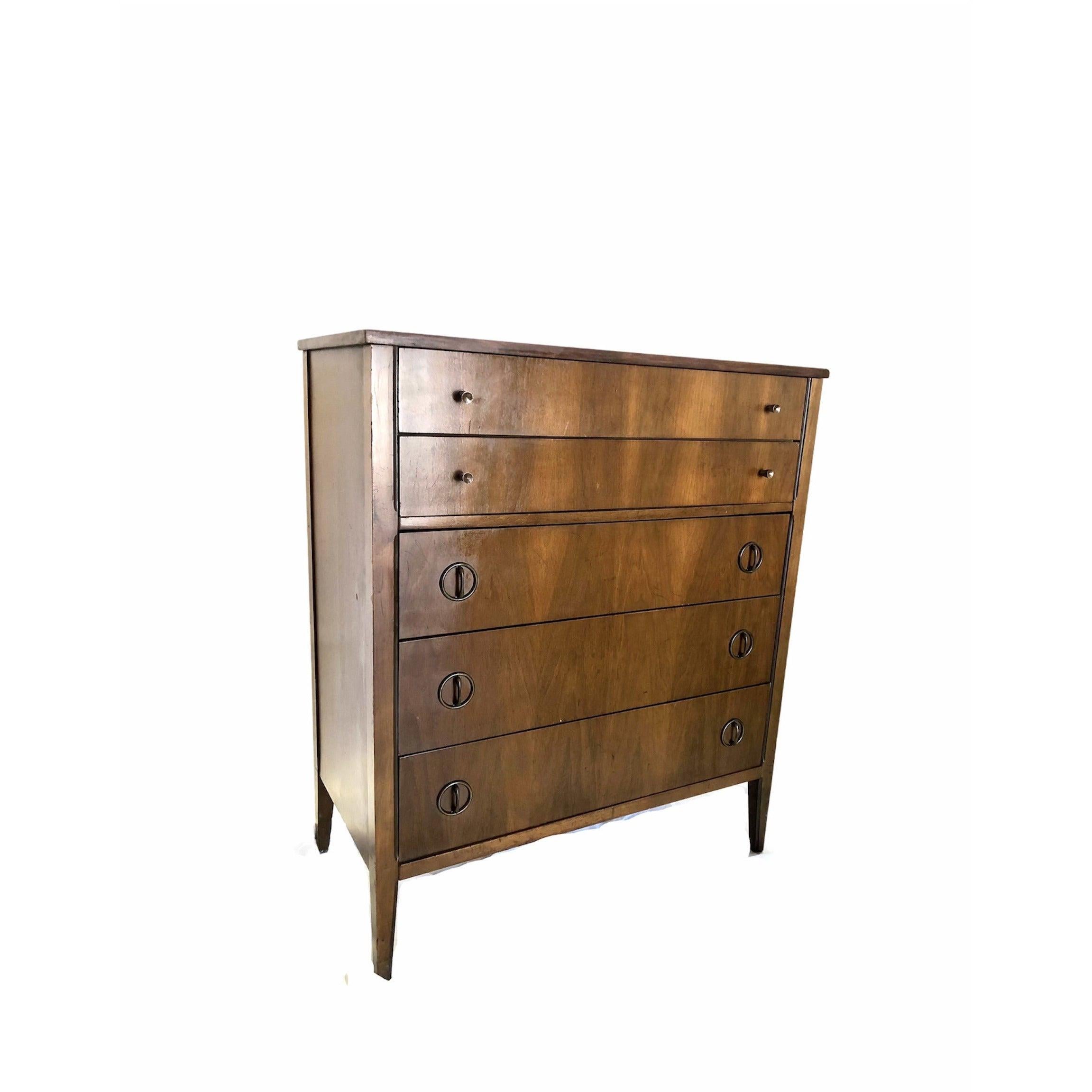 Vintage mid century modern tallboy dresser with six spacious drawers and original round metal pulls. This piece highlights elements of traditional woodworking, including dove tail joinery and tapered legs. Clean lines and subtle sculptural details