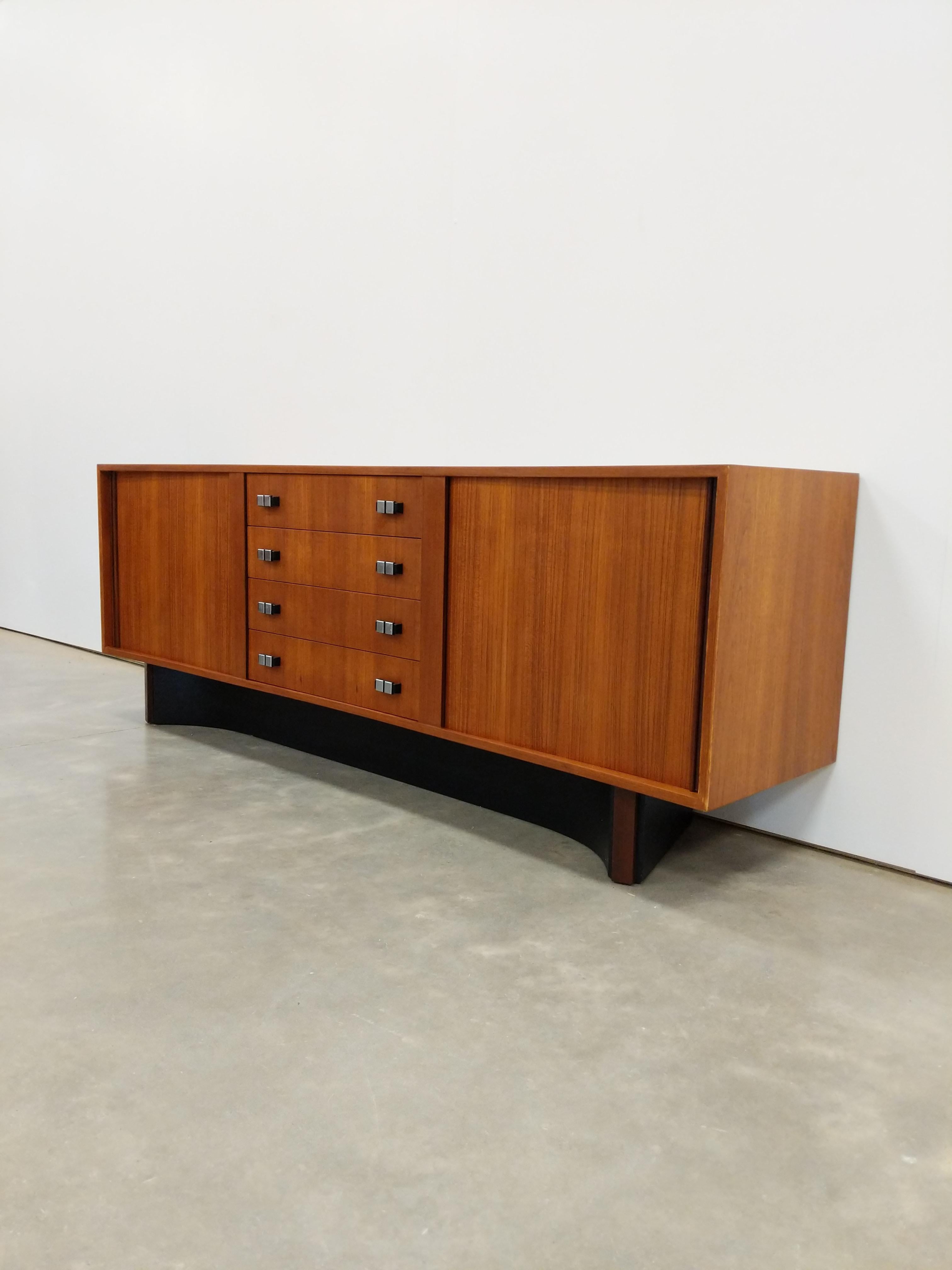 Authentic vintage mid century modern teak credenza / sideboard / media console.

By RS Associates.

Maker's stamp inside drawer.

The face of this piece is curved. It is a bit hard to see in the photos.

The drawer handles are metal.

This piece can