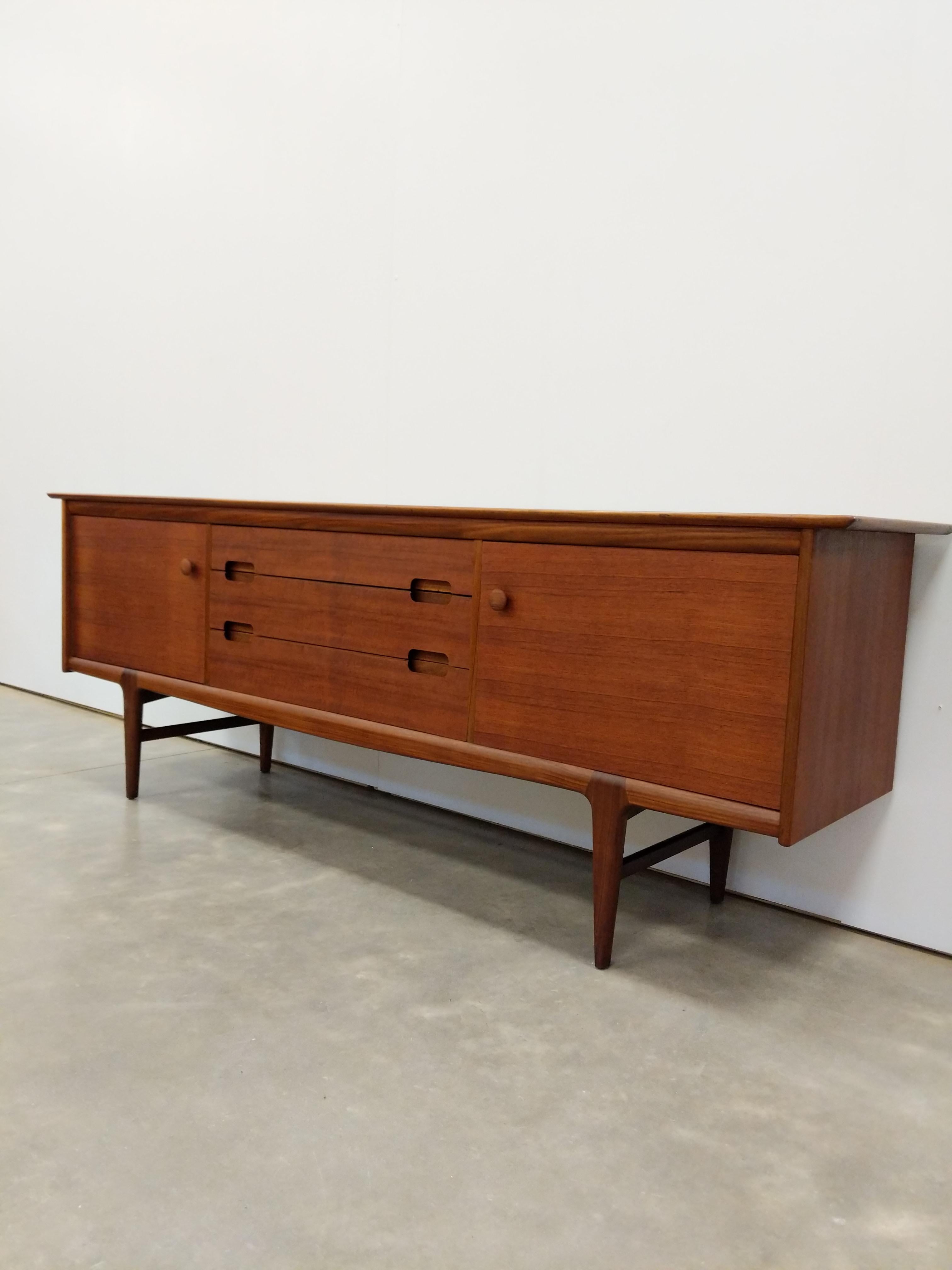 Authentic vintage mid century modern teak credenza / sideboard / console.

By Younger.

Maker's label inside door.

This piece is in excellent condition with very few signs of age-related wear (see photos).

If you would like any additional details,