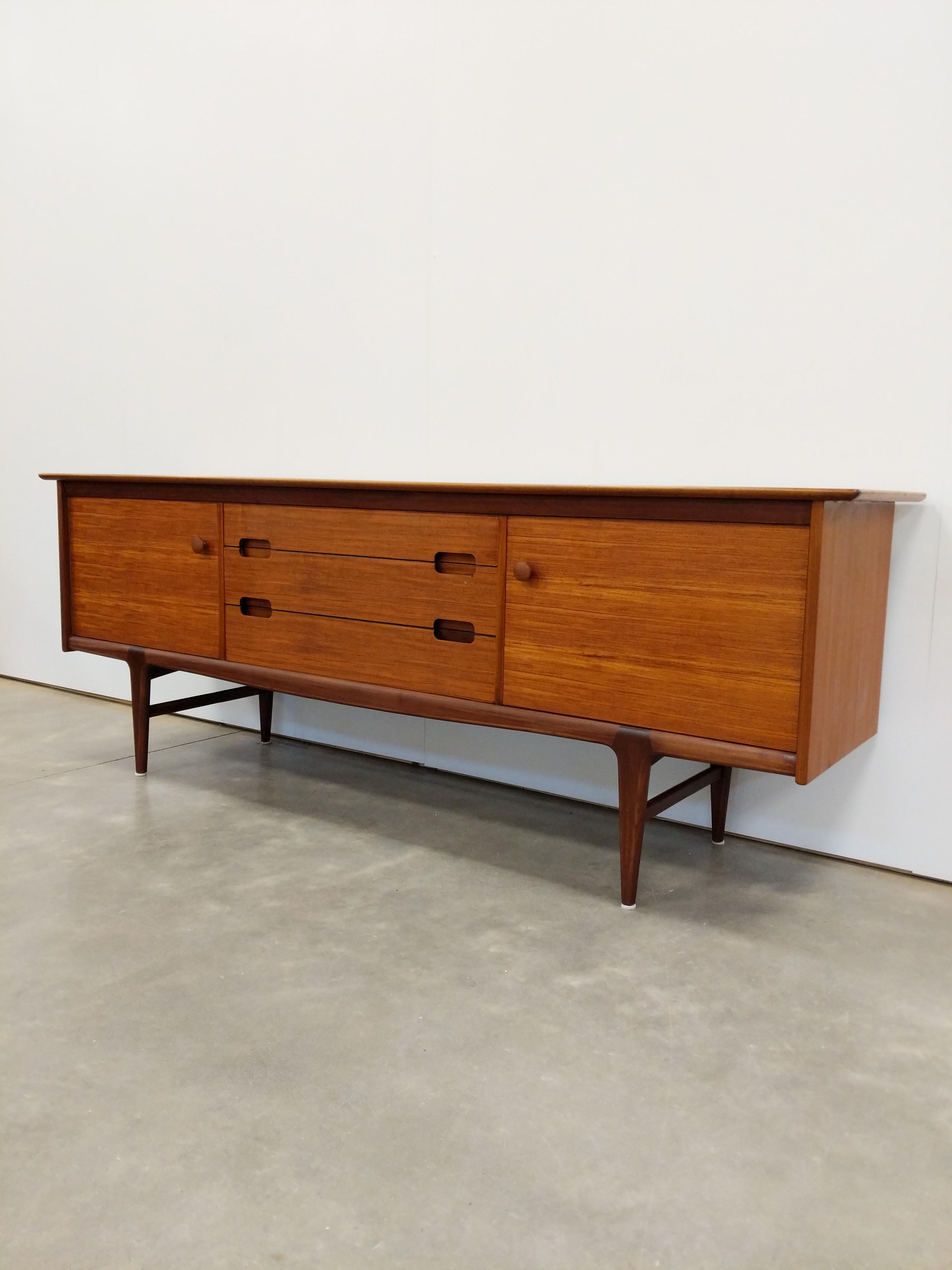 Authentic vintage mid century modern teak credenza / sideboard / console.

By Younger.

Maker's label inside door.

This piece is in excellent condition with very few signs of age-related wear (see photos).

If you would like any additional details,