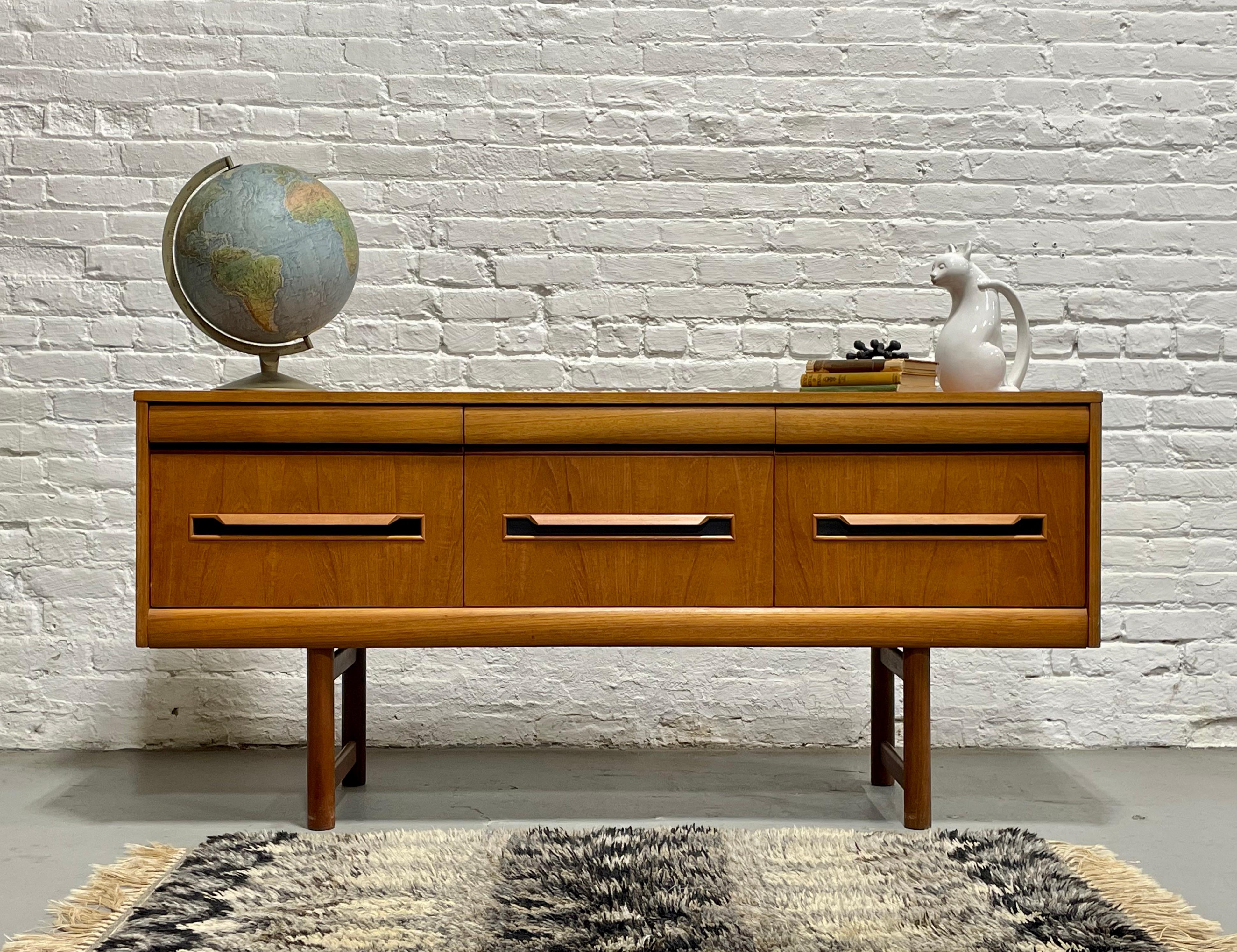 Apartment sized Teak Mid Century Modern Credenza / Sideboard by Elliotts of Newbury, c. 1960's. Loads of storage in three deep and spacious dovetailed drawers plus three smaller drawers.  Rounding out the design details are the sculpted handpulls