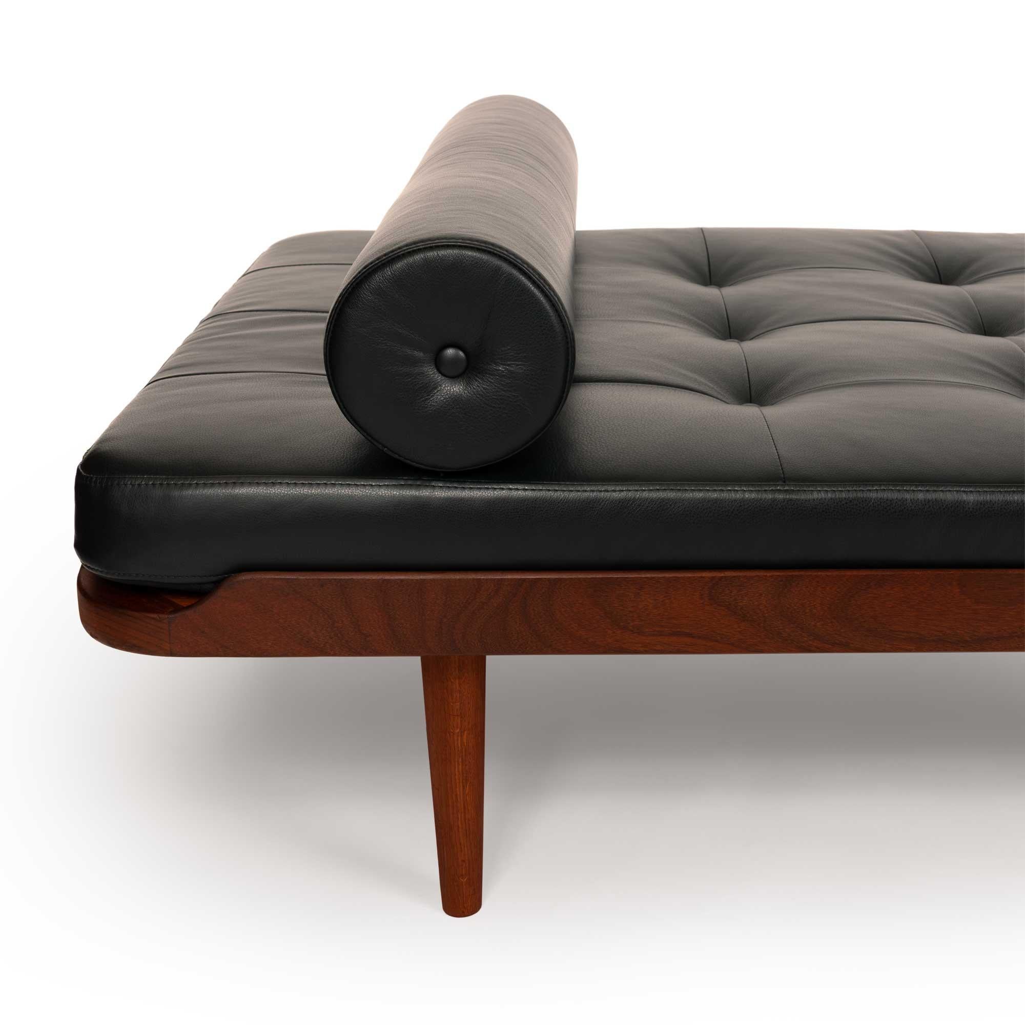 This stunning vintage Danish mid-century modern teak daybed has been expertly reupholstered in luxurious black leather by Arne Sørensen, elevating its timeless appeal. It features a solid teak frame with a rich, natural grain that highlights its