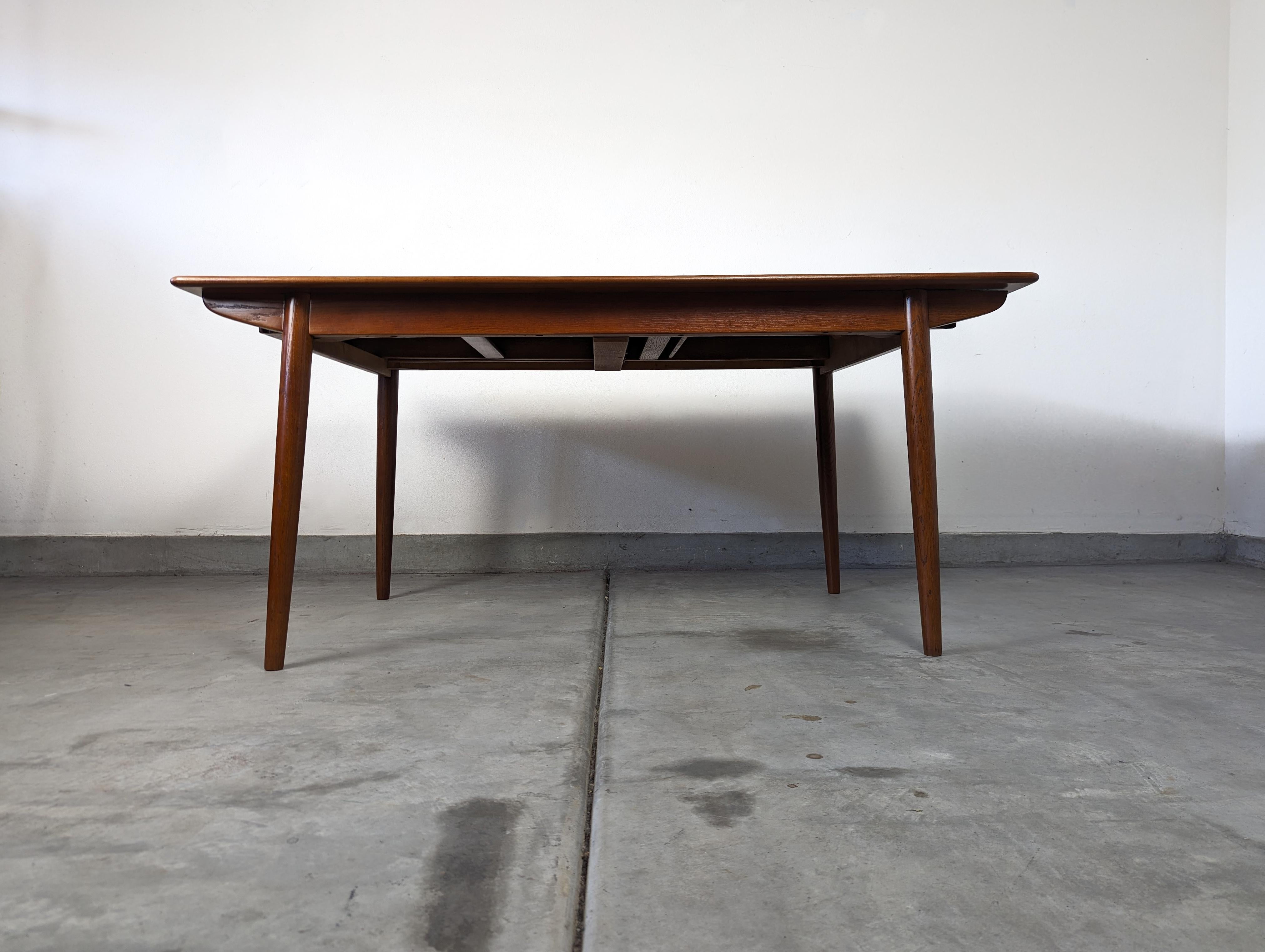 Elevate your dining experience with this stunning vintage Mid Century Modern teak dining table by Slagelse, a treasured piece from the 1960s. This remarkable and authentic piece hails from an era renowned for its timeless aesthetics and remarkable