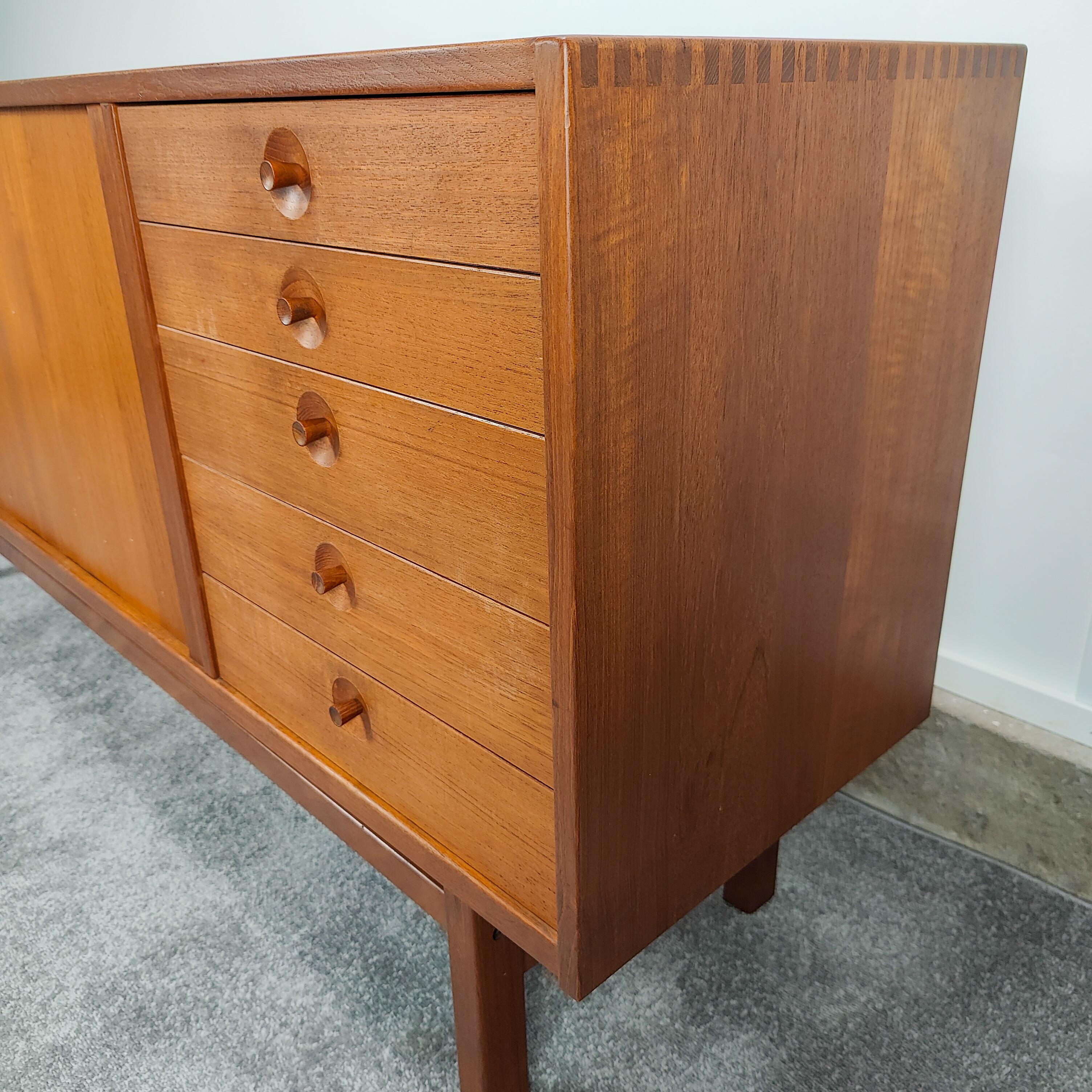 Nils Jonsson for Troeds solid teak sideboard with tambour doors. Features striking joinery and impressive drawer pulls in great original condition.
Measures approximately 68W x 16.5D x 31T.

 