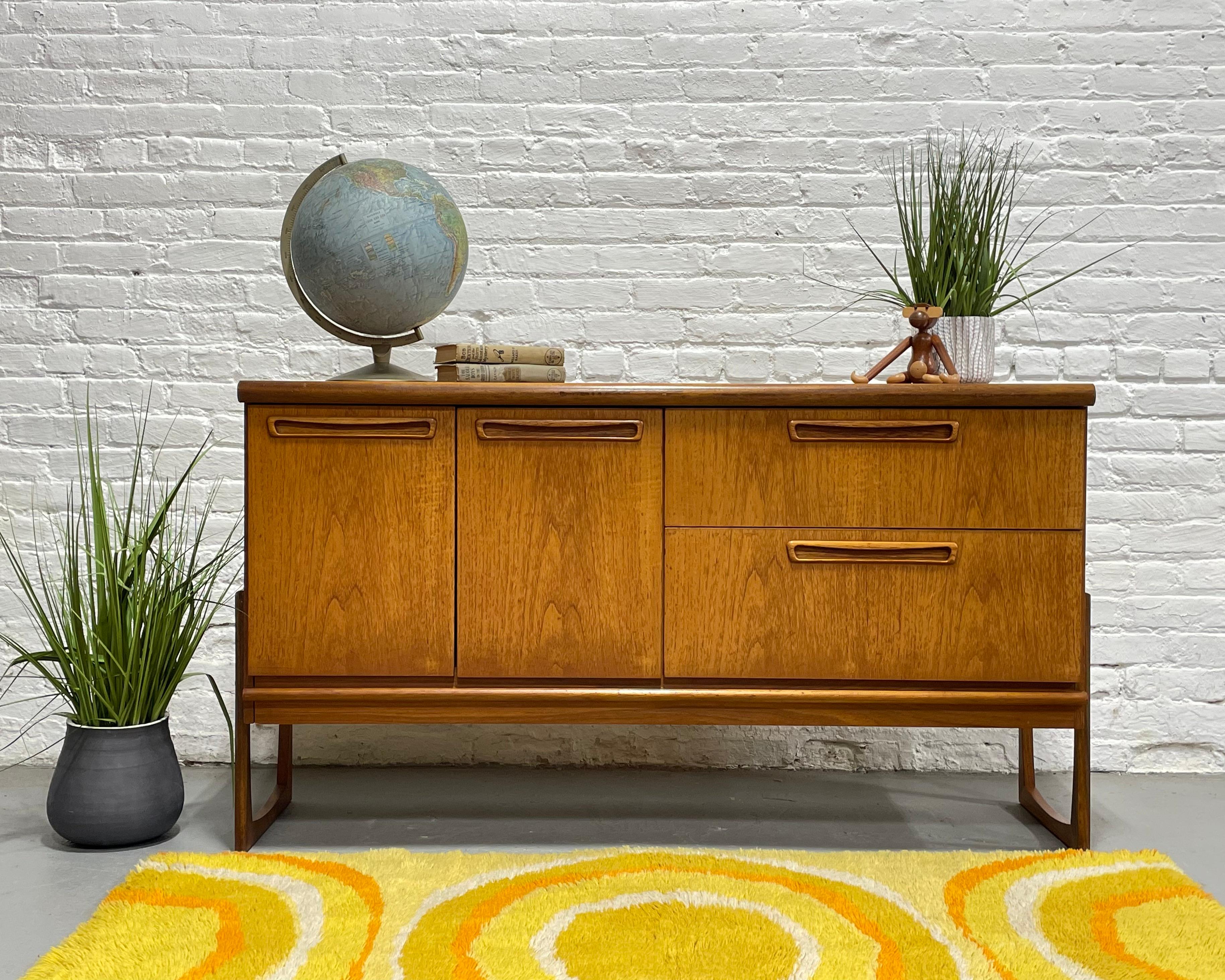 Apartment sized Vintage Mid Century Modern Teak Credenza / Sideboard, c. 1960's. The legs are the true showstopper of this piece, offering a unique square design that is not only gorgeous to look at and gives the case a 