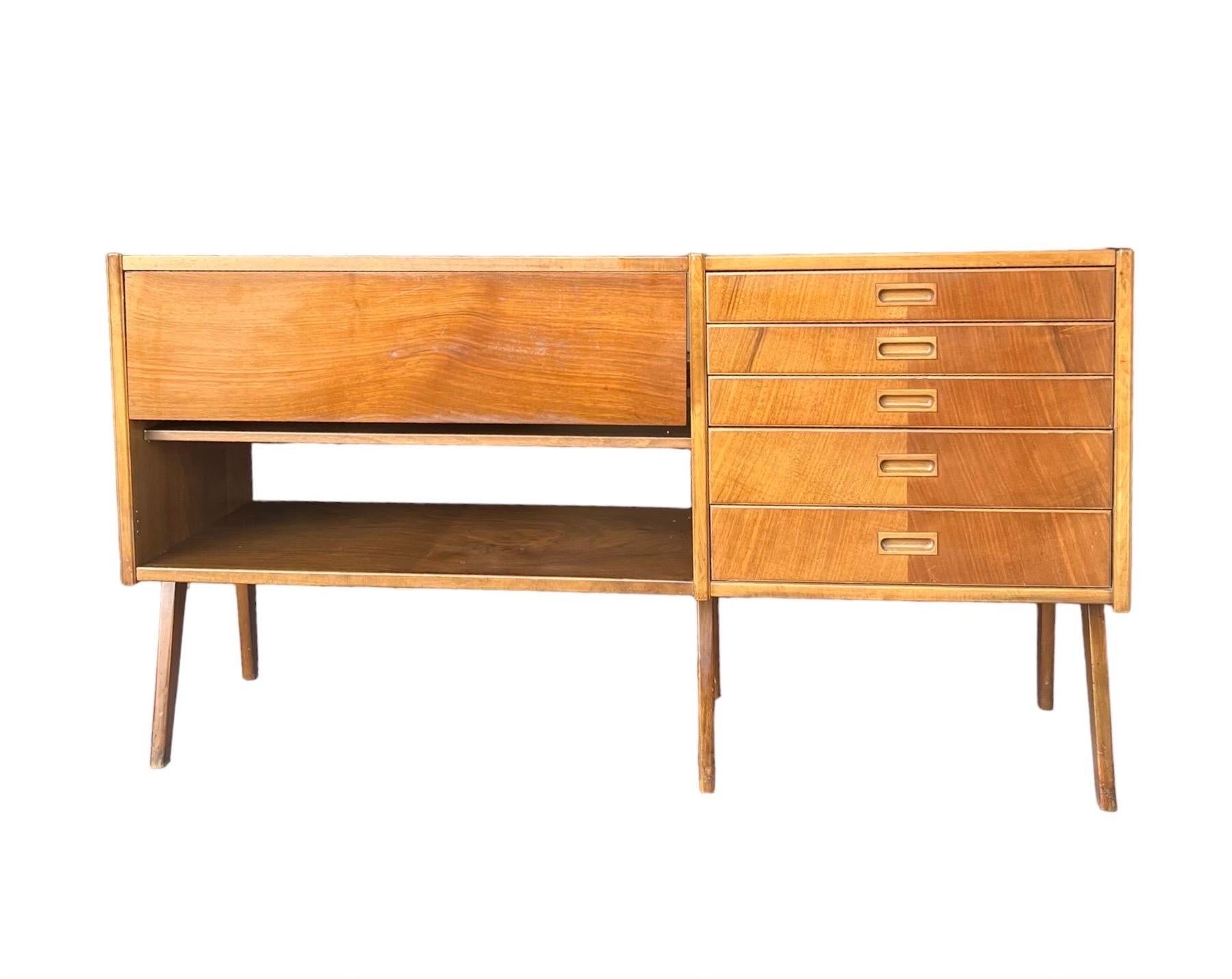 Vintage Mid Century Modern credenza or buffet, made in Sweden! A unique and well made piece featuring a drop down leaf to extend your top surface space, open tiered shelving for storage and 5 pull out drawers. Shelves are adjustable if you'd like to