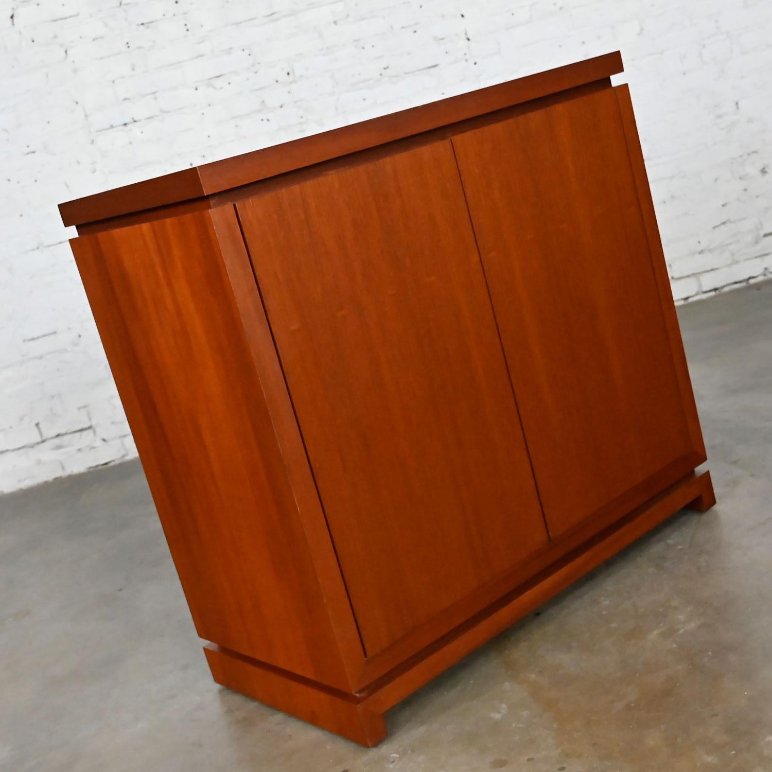 Lovely vintage Mid-Century Modern to modern narrow walnut console cabinet with rosewood colored stain, double doors, and an adjustable interior shelf. Beautiful condition, keeping in mind that this is vintage and not new so will have signs of use