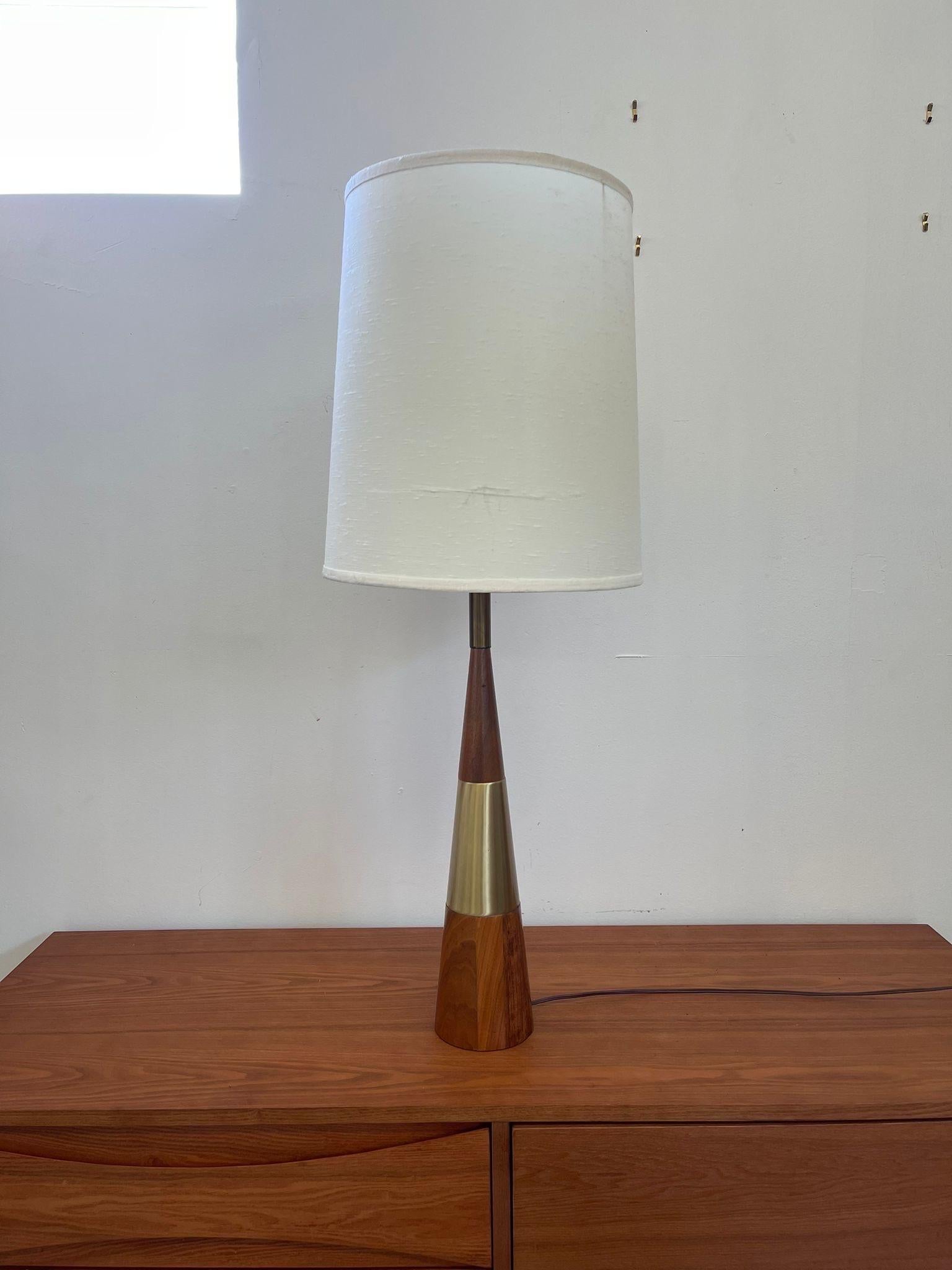 Fully Functional Cone Shaped Tall Vintage Lamp. Base of the Lamp Has Brass Toned Accent and Walnut Toned Wood. Possibly 1950s. Vintage Condition Consistent with Age as Pictured. Light Bulb not Included.

Dimensions. Base 5 ; Diameter ; 37 H

       