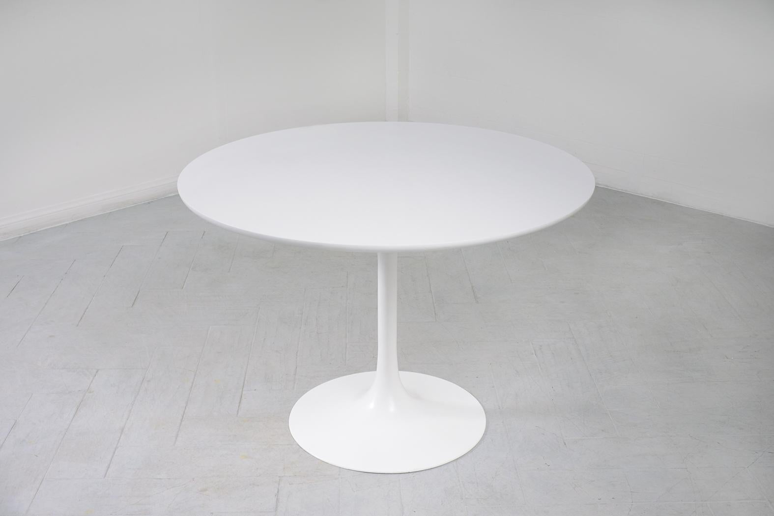 This Classic Mid-Century Modern round Tulip pedestal table in the manner of Saarinen Knoll Comfortably seats four people. Features original white satin smooth laminate 42 round 1.06 thick beveled edge top. This remarkable teak table is raised on a