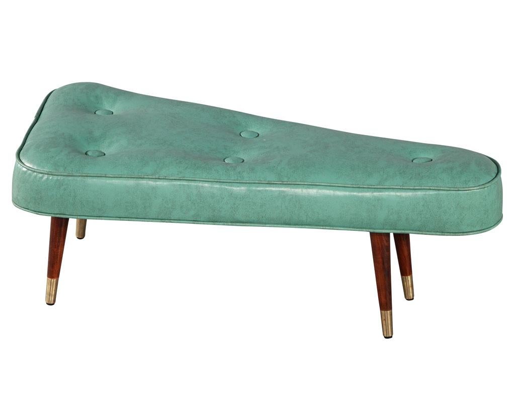 Vintage Mid-Century Modern turquoise triangular shaped ottoman bench. All original, USA, circa 1970's. Distressed aged turquoise vinyl with tufted design. Completed with sleek walnut wood legs with brass caps. Price includes complimentary curb side