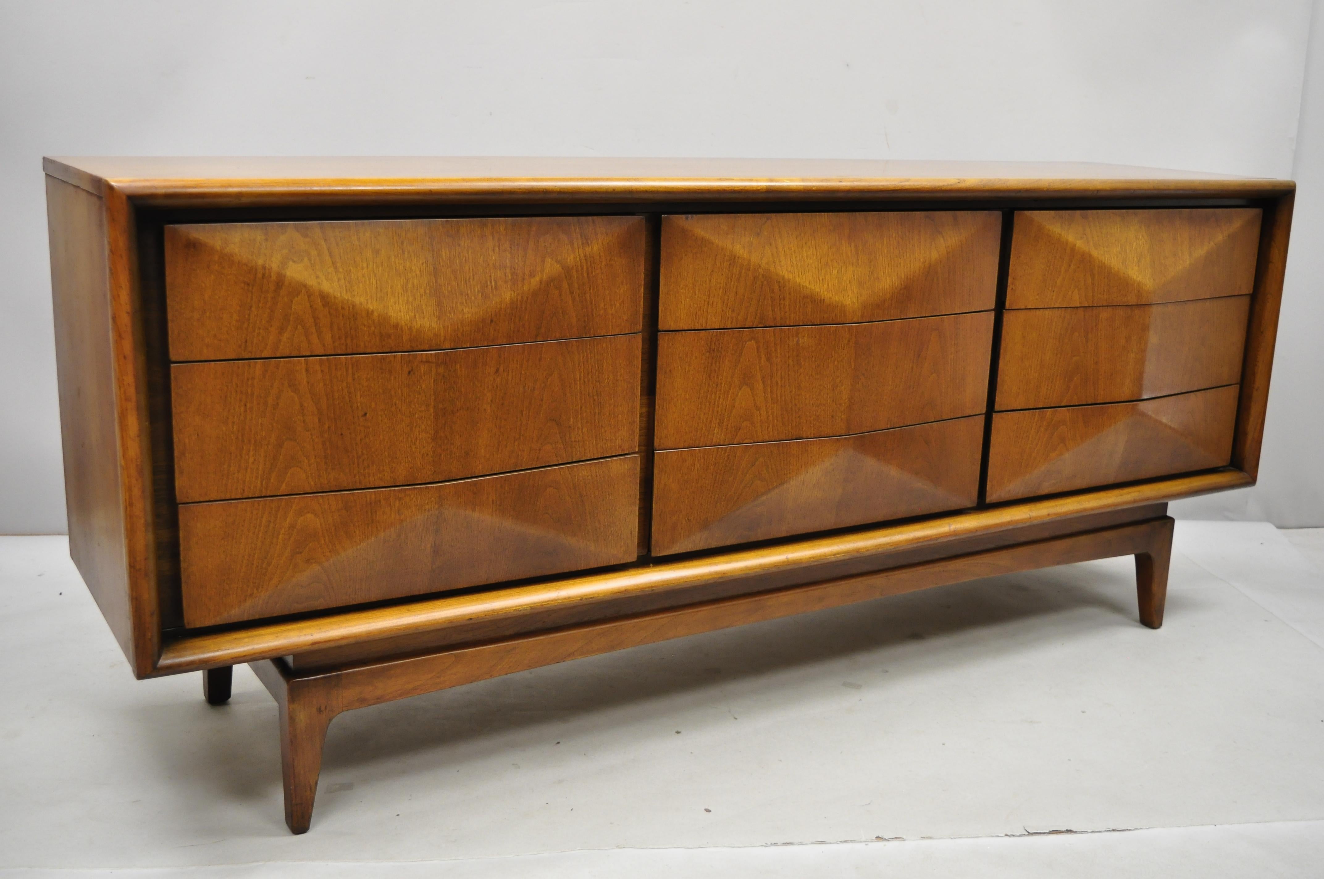 Vintage Mid-Century Modern walnut 3 dimensional 9-drawer dresser credenza. Item includes 3 dimensional diamond fronts, beautiful wood grain, 9 dovetailed drawers, tapered legs, clean modernist lines, great style and form, circa mid-20th century.