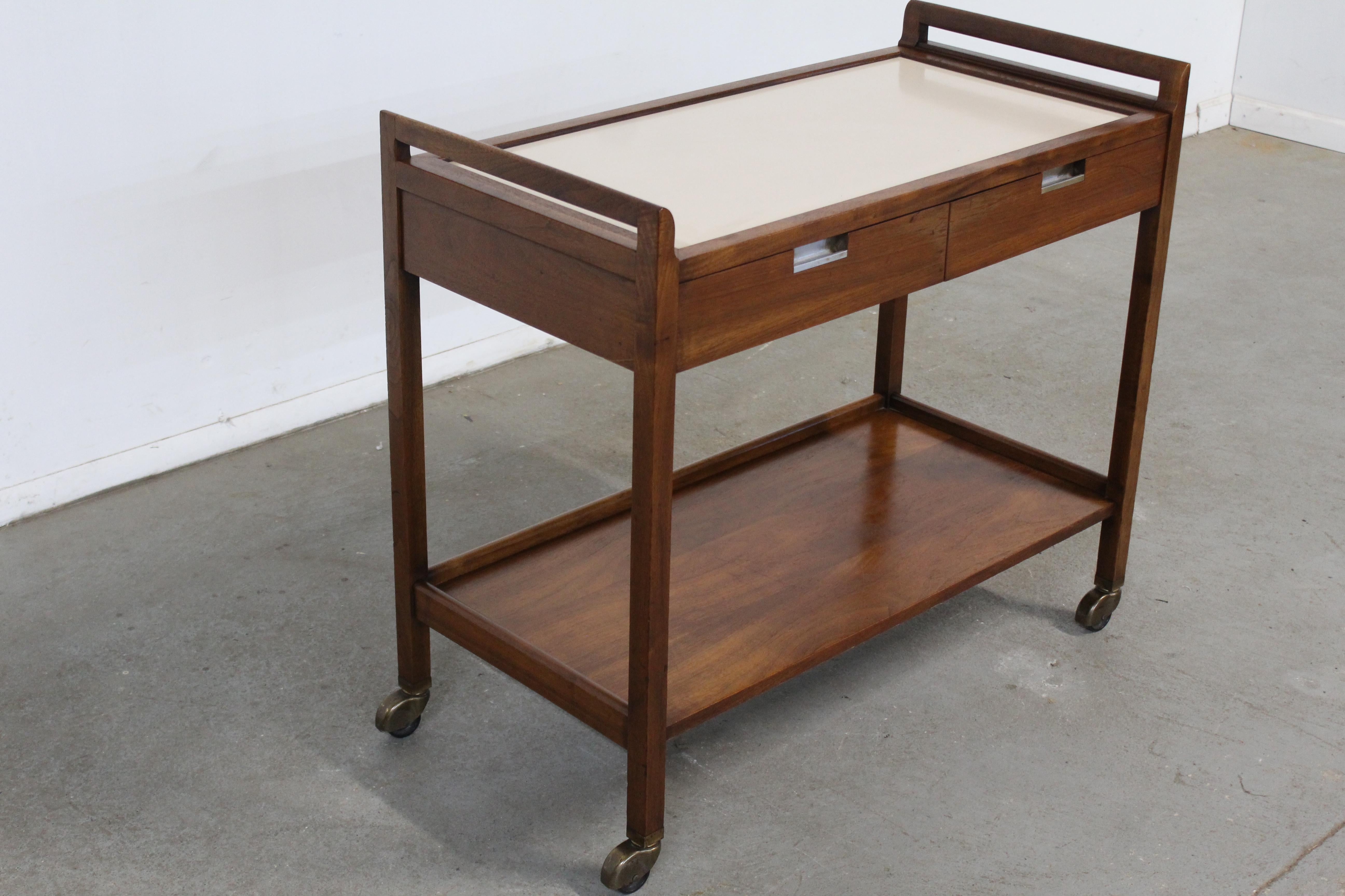 Vintage Mid-Century Modern walnut bar cart by Merton Gershun on Wheels.
 Offered is a very cool Modern Walnut bar cart. Features two drawer, spill proof top and large bottom shelf. It is also on wheels. Designed by Merton Gershun for American of