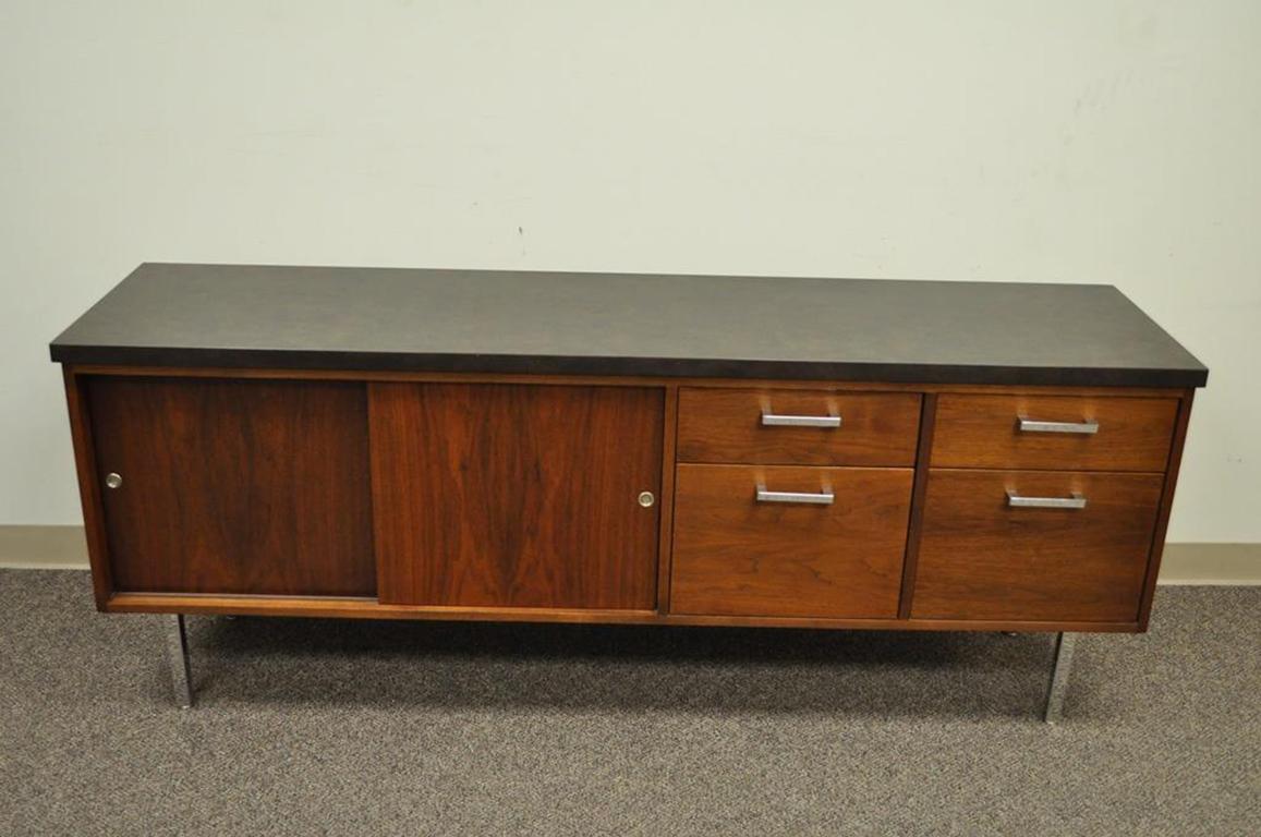 Sleek vintage Mid-Century modern laminate top walnut credenza. Item features a gray marbled laminate top, sliding cabinet doors, four-drawer, chrome legs, substantial weight, and a rich natural wood grain. The piece is unmarked, but appears very