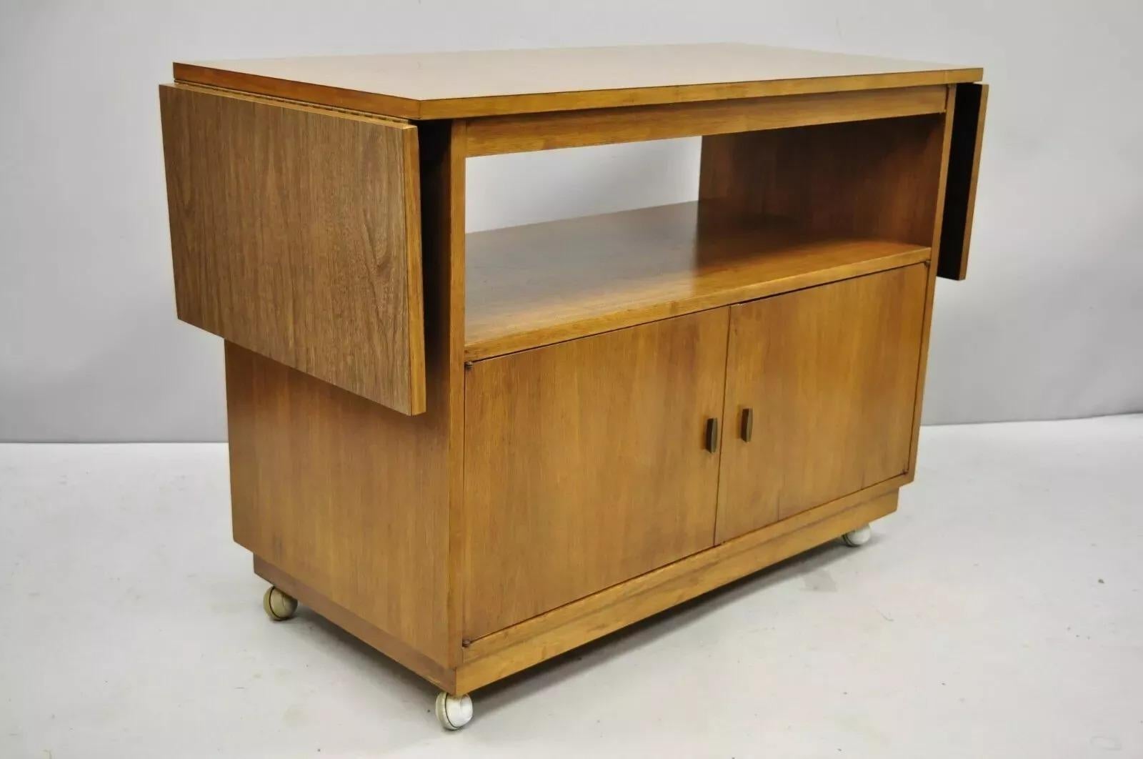 Vintage Mid Century Modern Walnut Laminate Top Rolling Drop Leaf Bar Cart Server. Item features a drop leaf laminate top, lower shelf, rolling casters, beautiful wood grain, finished back, 2 swing doors, very nice vintage item, clean modernist
