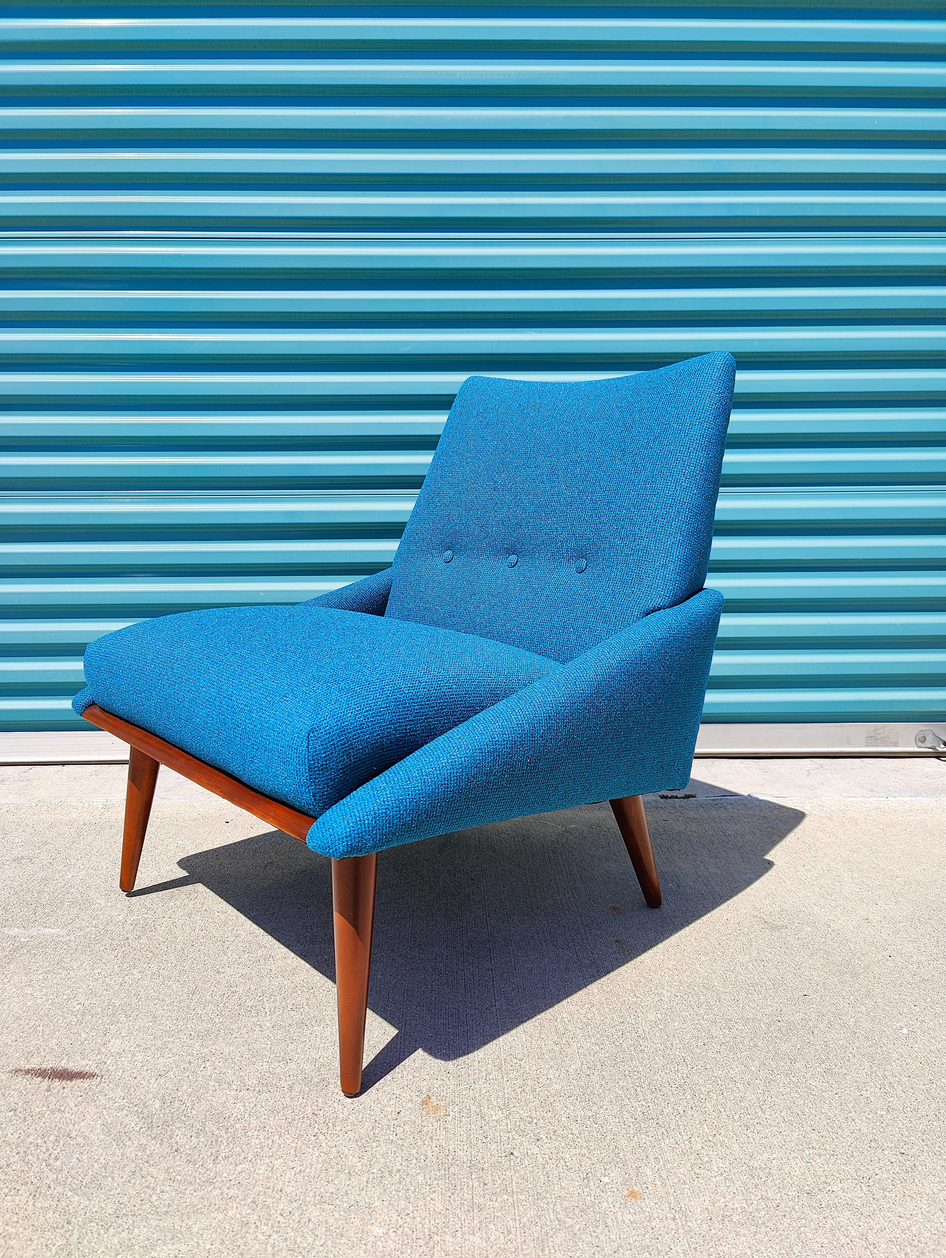Recently refinished in electric blue fabric and overall in excellent condition. Features the classic walnut wood legs with clean simple lines. Measures approximately 25w x 23d x 31t with a seat height of 17 inches. Would look great in a mid century
