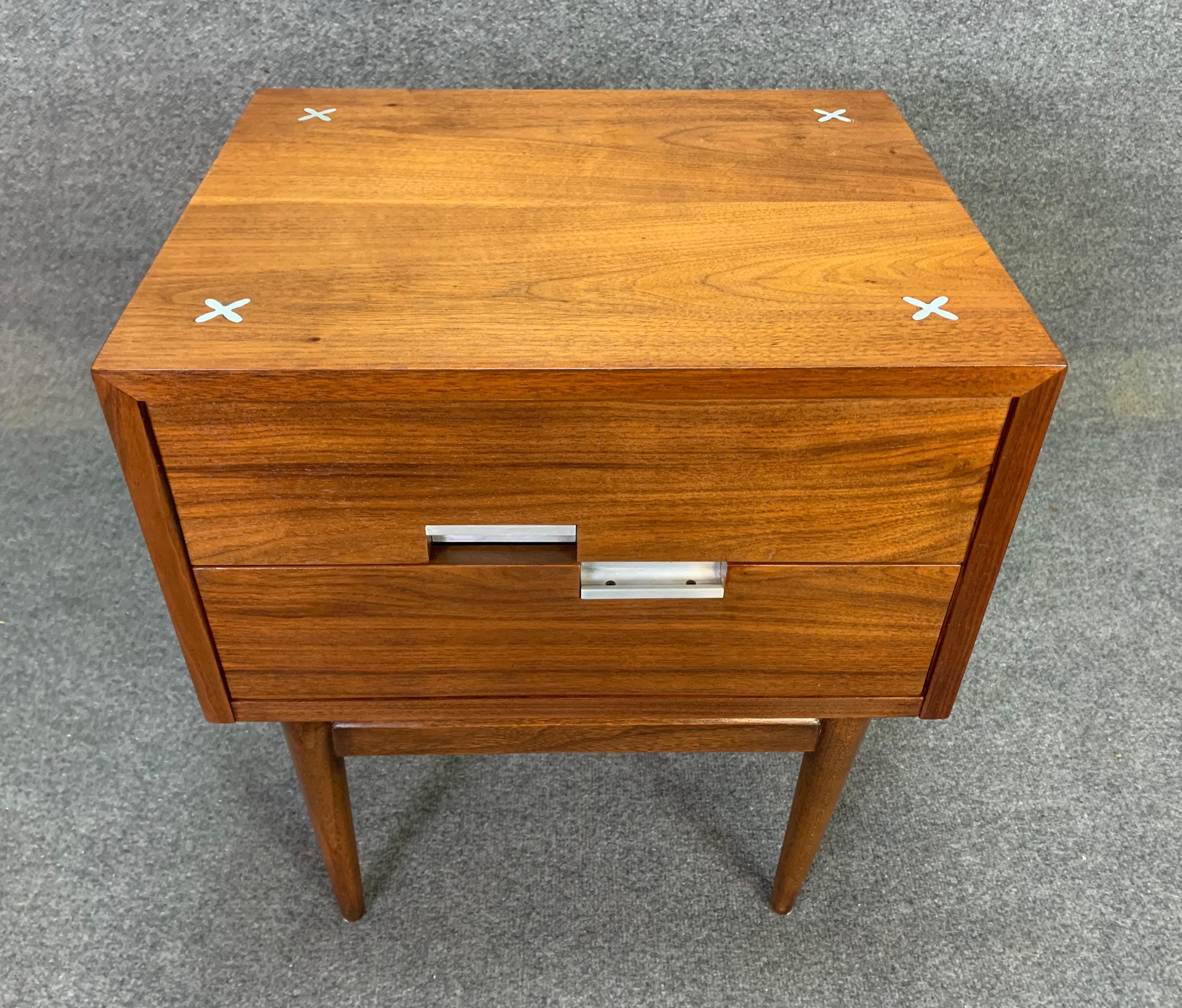Here is a beautiful single night or side table in walnut designed by Merton Gershun and manufactured in the US by American of Martinsville in the 1960s. This fully refinished and exquisite piece features a set of 2 dove tail drawers with aluminum