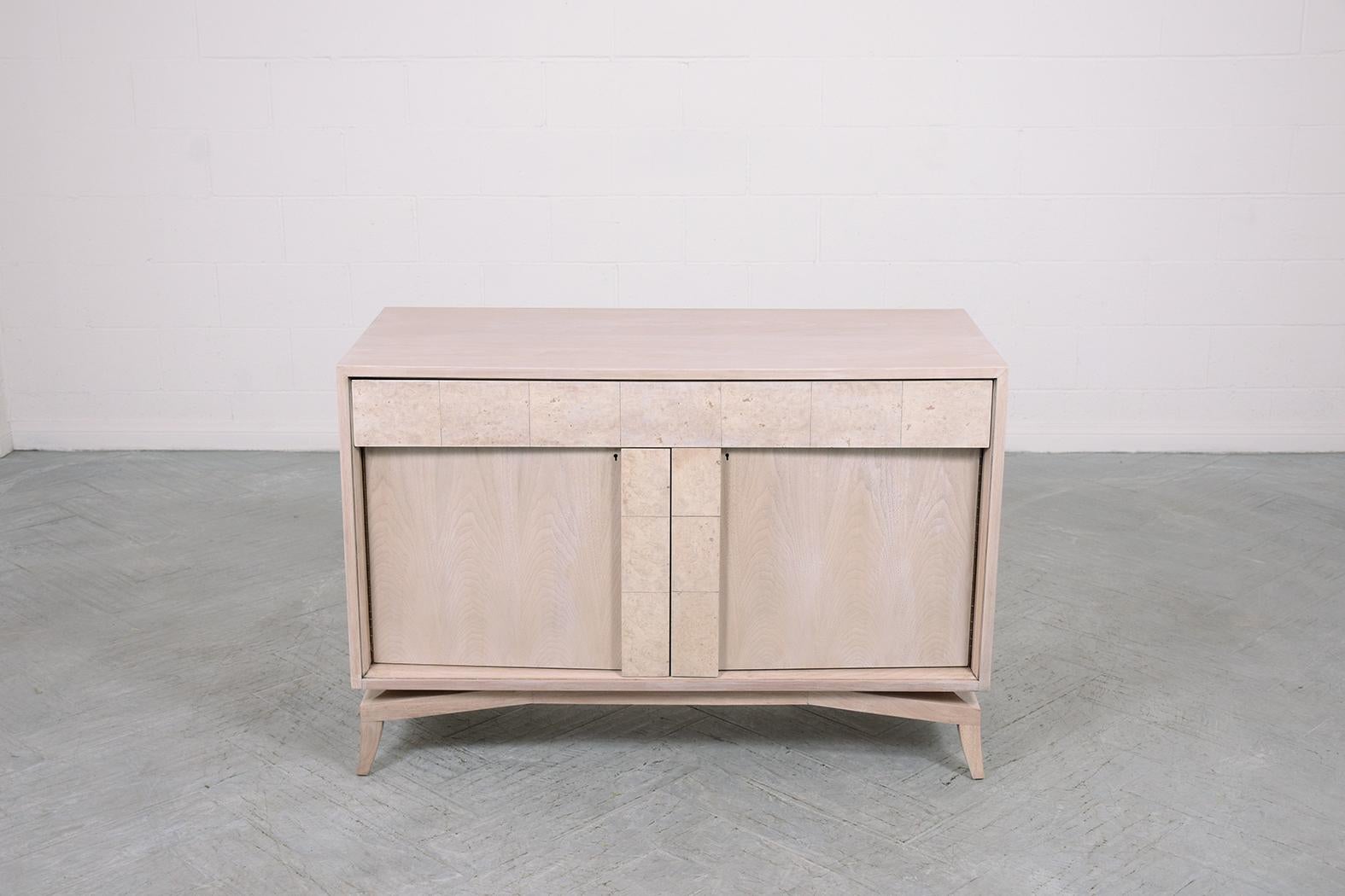 Discover a masterfully restored 1960s credenza, hand-crafted from premium walnut. This exceptional piece, brought back to life by our expert craftsmen, captivates with its soft whitewashed hue, sealed with a protective lacquered finish. The design