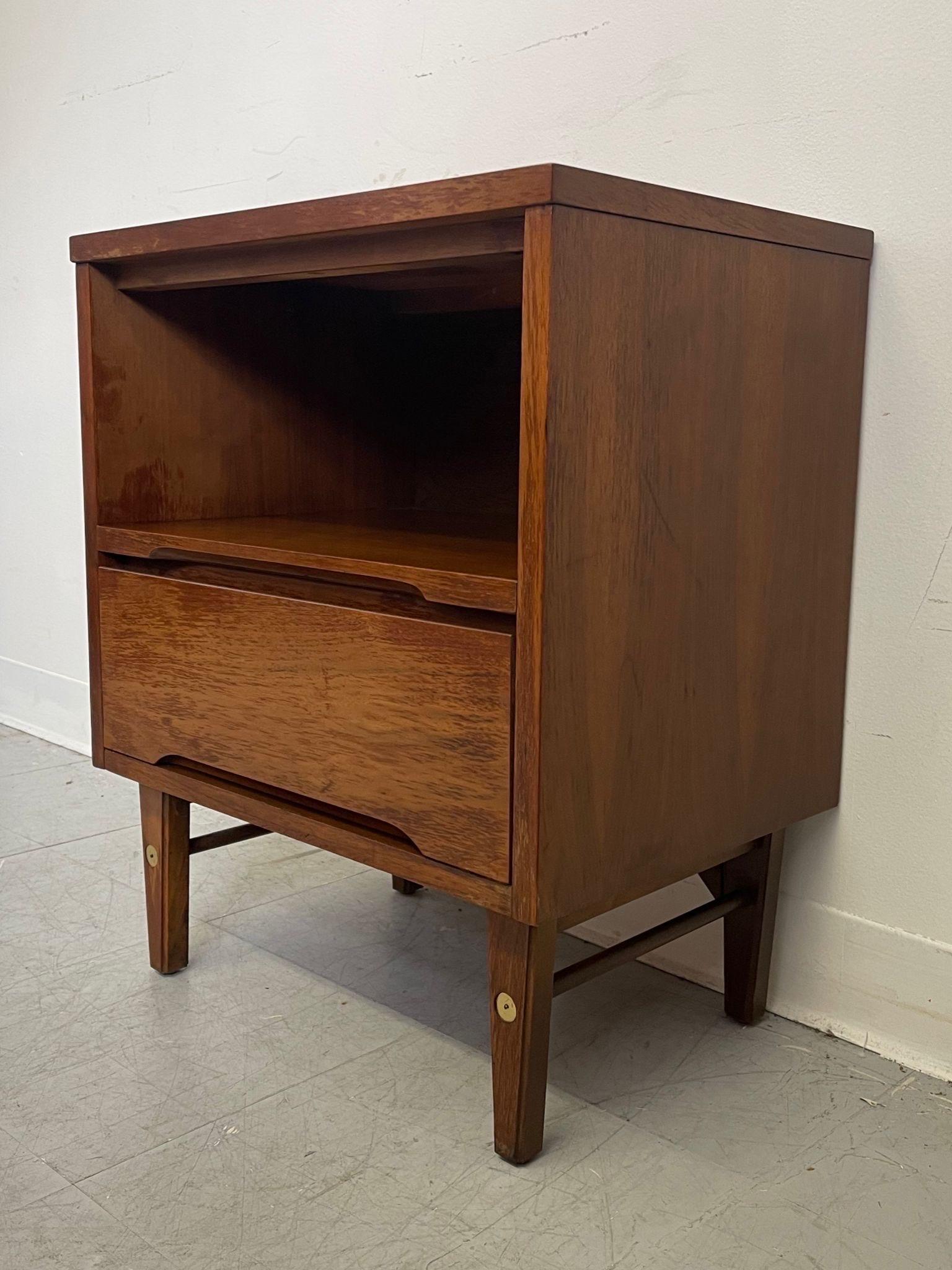 This End Table has an open shelf above a single dovetailed drawer with the maker’s mark inside. Wood carved recessed handle. Tapered legs with brass toned accents. Vintage Condition Consistent with Age as Pictured.

Dimensions. 20 W ; 24 D ; 24 1/4 H