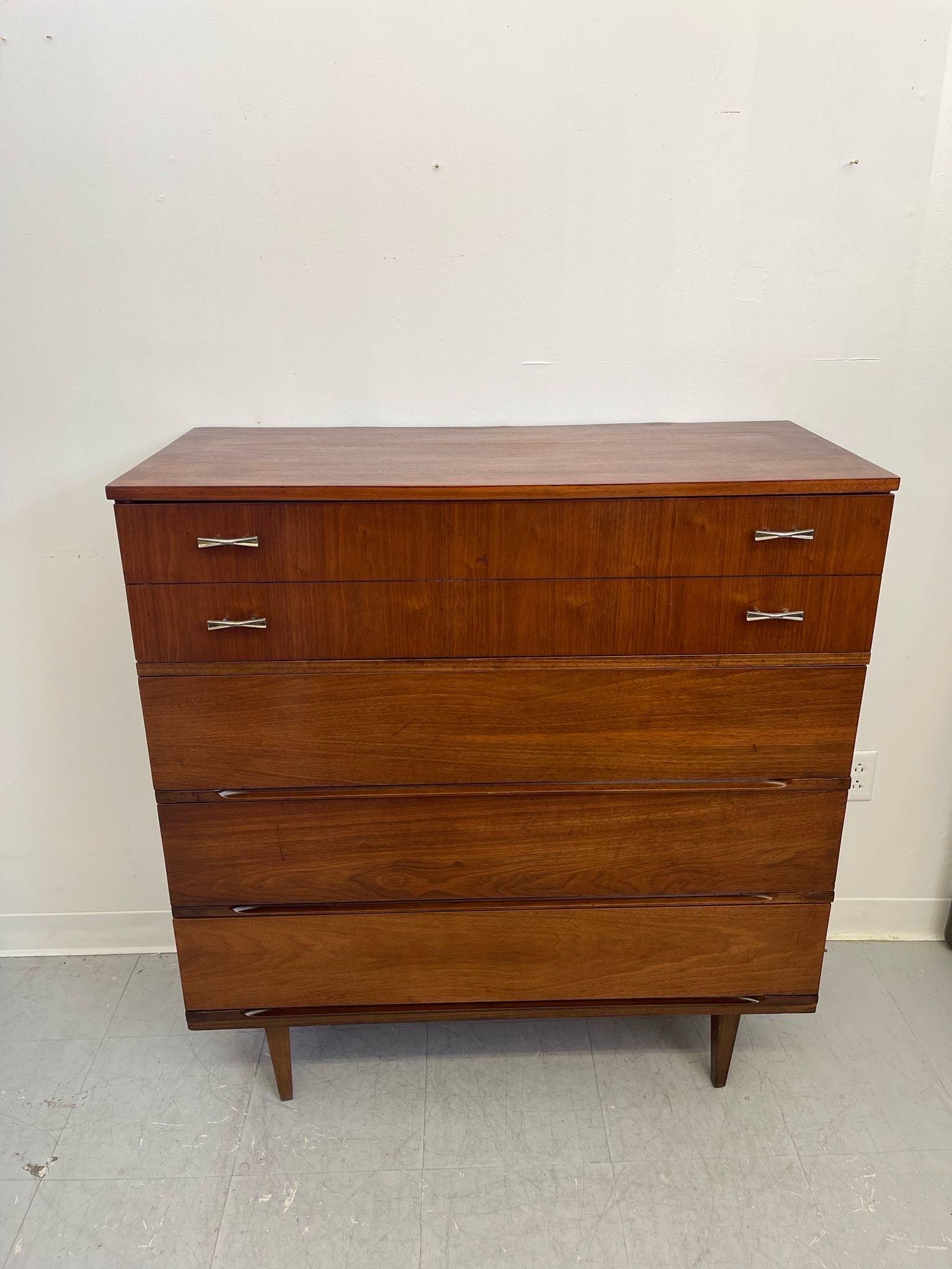This Four Drawer Dresser features original hardware to the top Drawer and tapered legs. Classic Mid Century design by Harmony House. Makers mark on the inside of the drawer as pictured. Vintage Condition Consistent with Age as Pictured.

Dimensions.