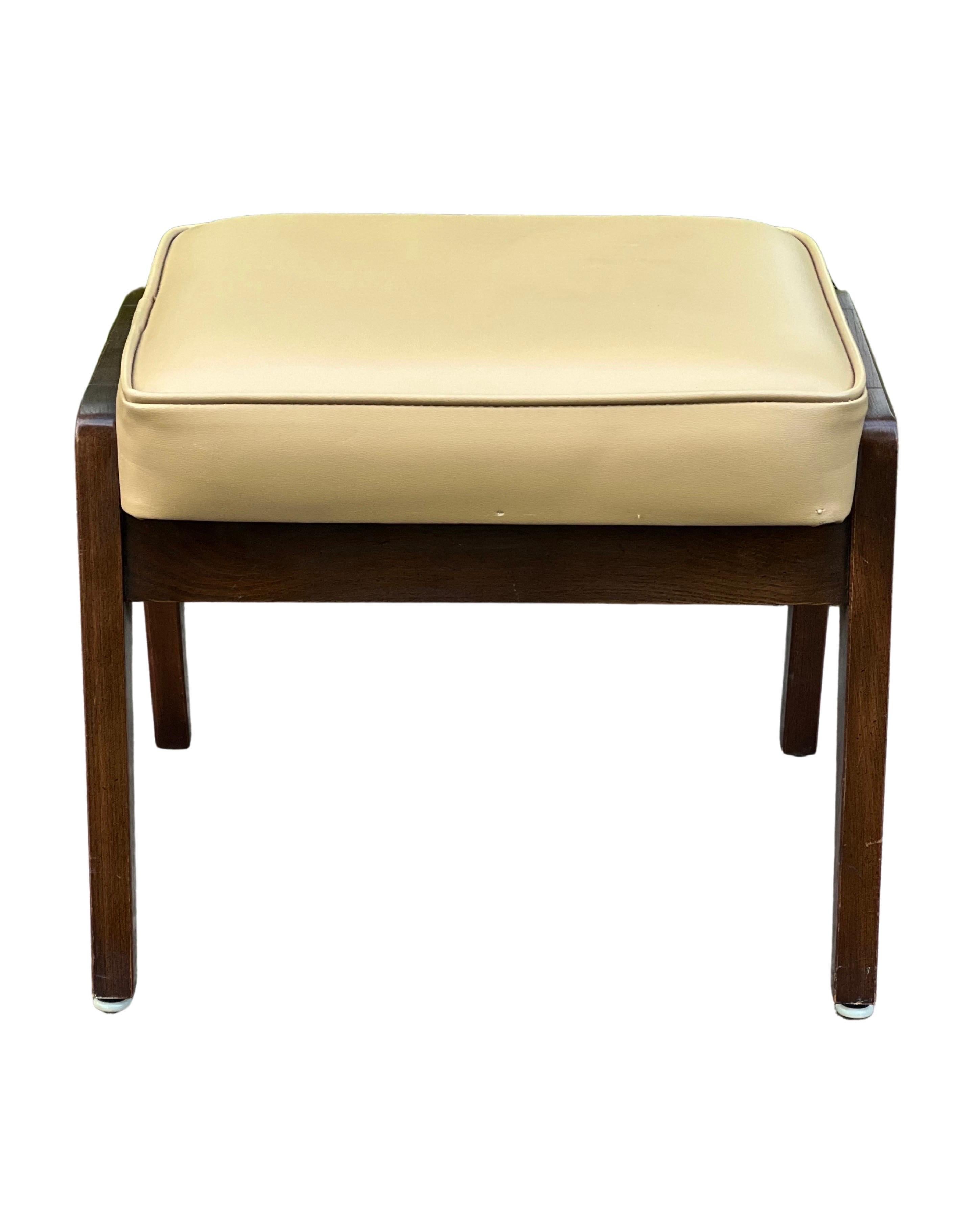 Mid century walnut upholstered footstool, 1950's.

Clean vintage walnut footstool in camel faux leather upholstery with classic mid century modern design. Great for so many uses, whether as extra seating or as a convenient footrest pulled up to a