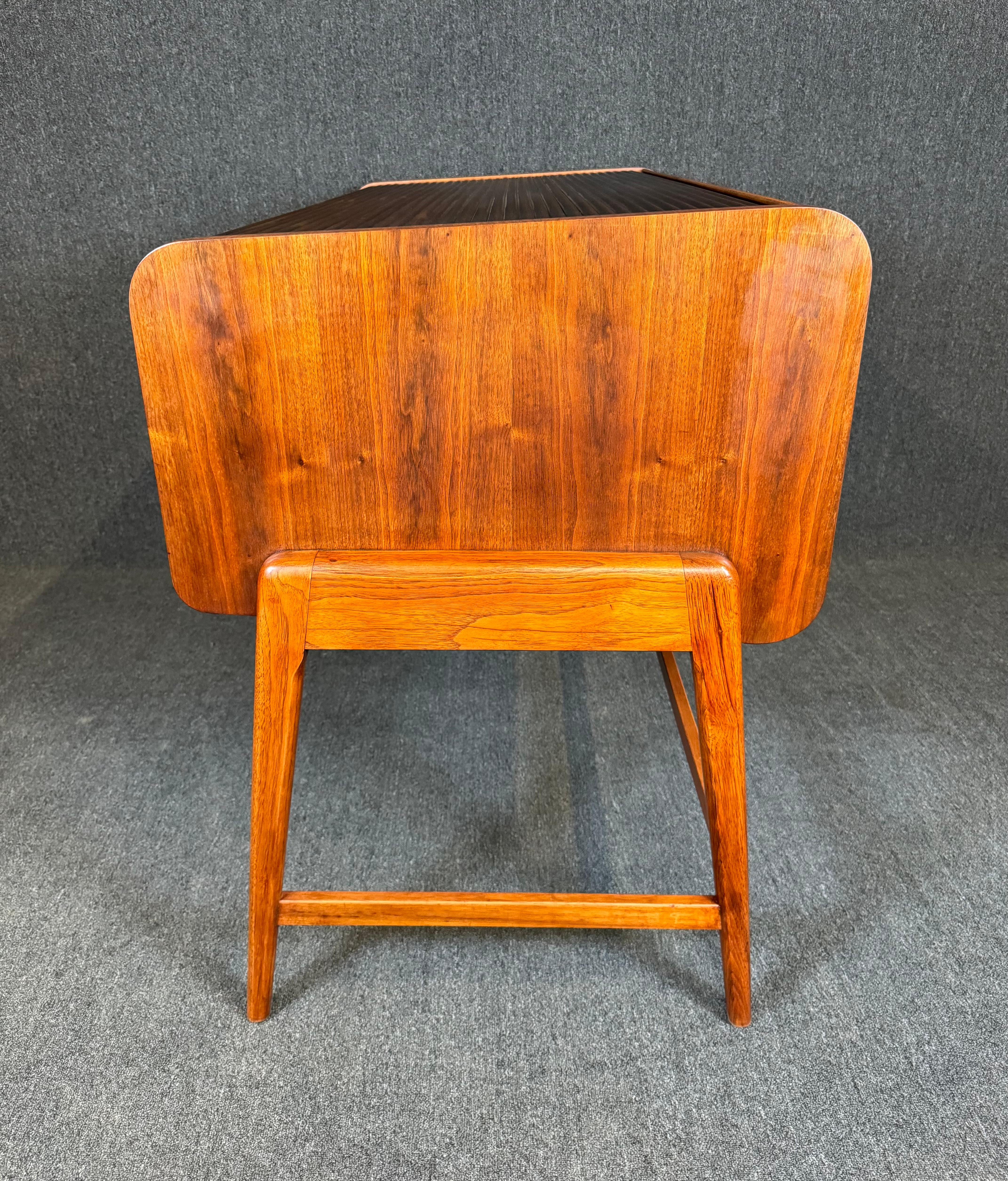 Here is a beautiful and rare desk in walnut manufactured by Sligh-Lowry in the USA in the late 1950's.
This refinished and exquisite desk features a vibrant wood grain, a large smooth rolling top revealing multiple storage options with 2 drawers,