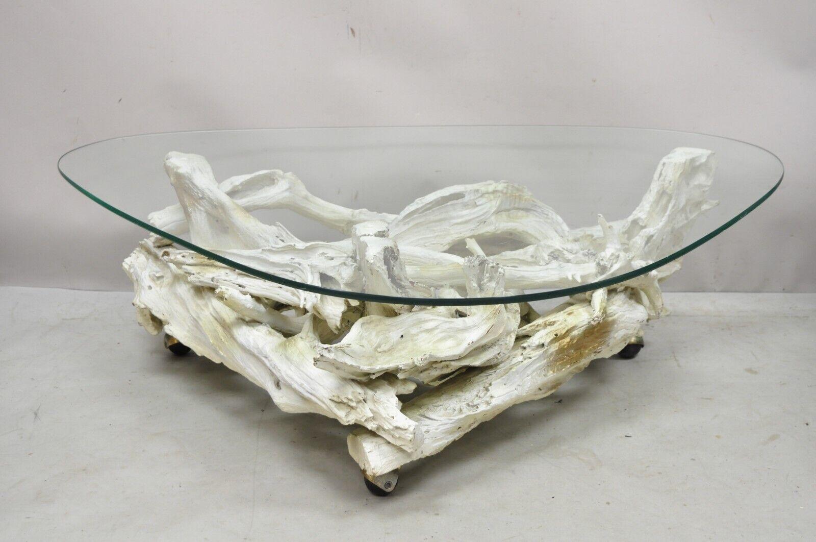 Vintage Mid-Century Modern white driftwood base glass top coffee table. Item features a sculptural driftwood base, shaped glass top, rolling casters, white and gold distress painted finish. Circa mid-20th century. Measurements: 14.75