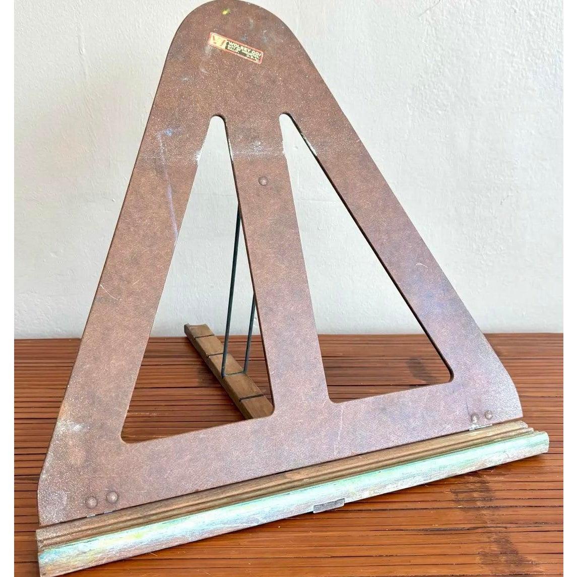 Dieser klappbare Bücherständer oder diese Staffelei im Vintage-Stil mit seinem dreieckigen Ausschnitt und seiner warmen braunen Patina verbindet funktionale Einfachheit mit dem Charme der Jahrhundertmitte. Er besteht aus einem faserplattenähnlichen