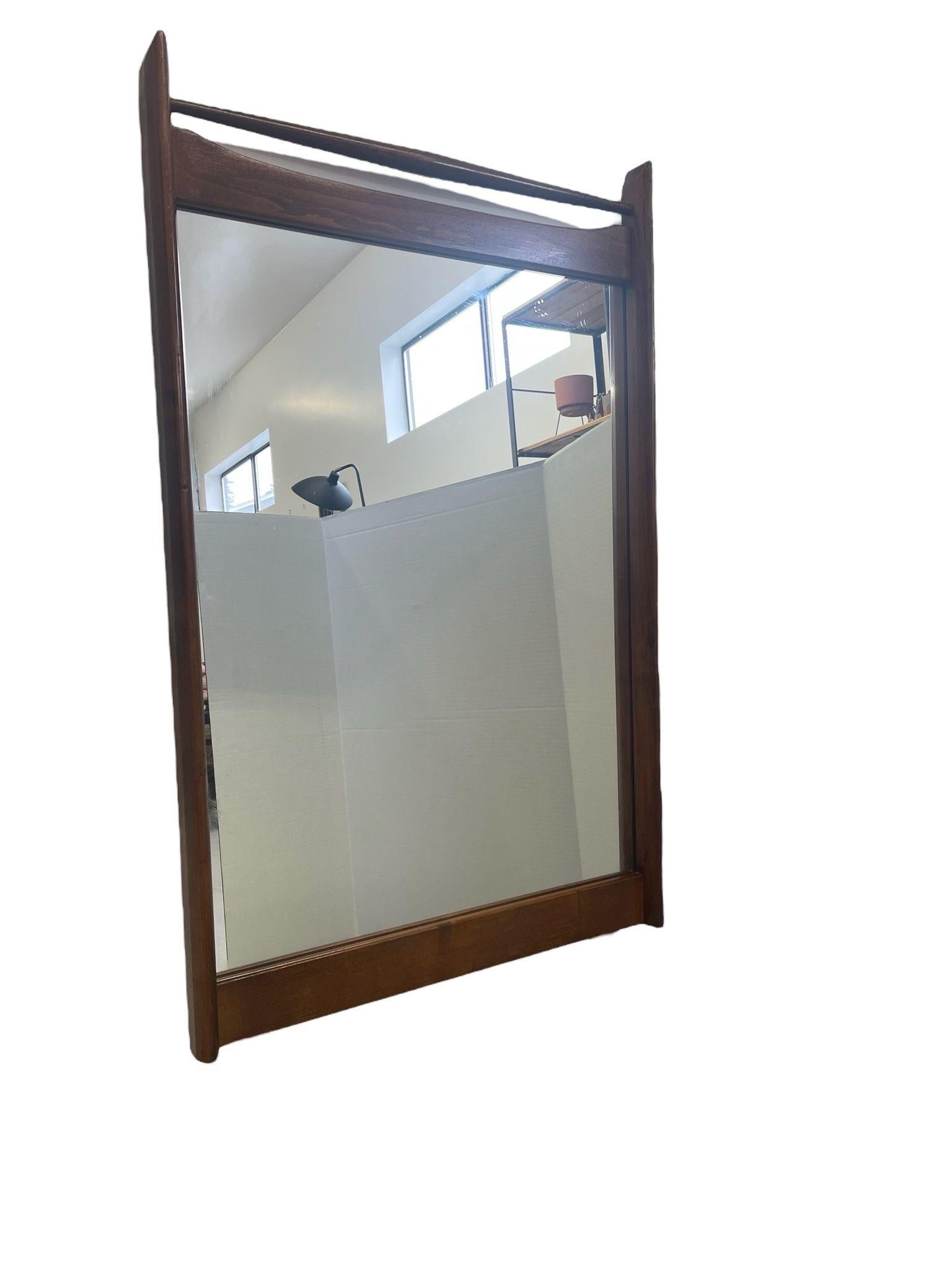 Wood Framed Tall Mirror with Sculpted Frame at the Top. No Makers Mark. Vintage Condition Consistent with Age as Pictured. 

Dimensions. 25 W ; 1/2 D ; 41 H