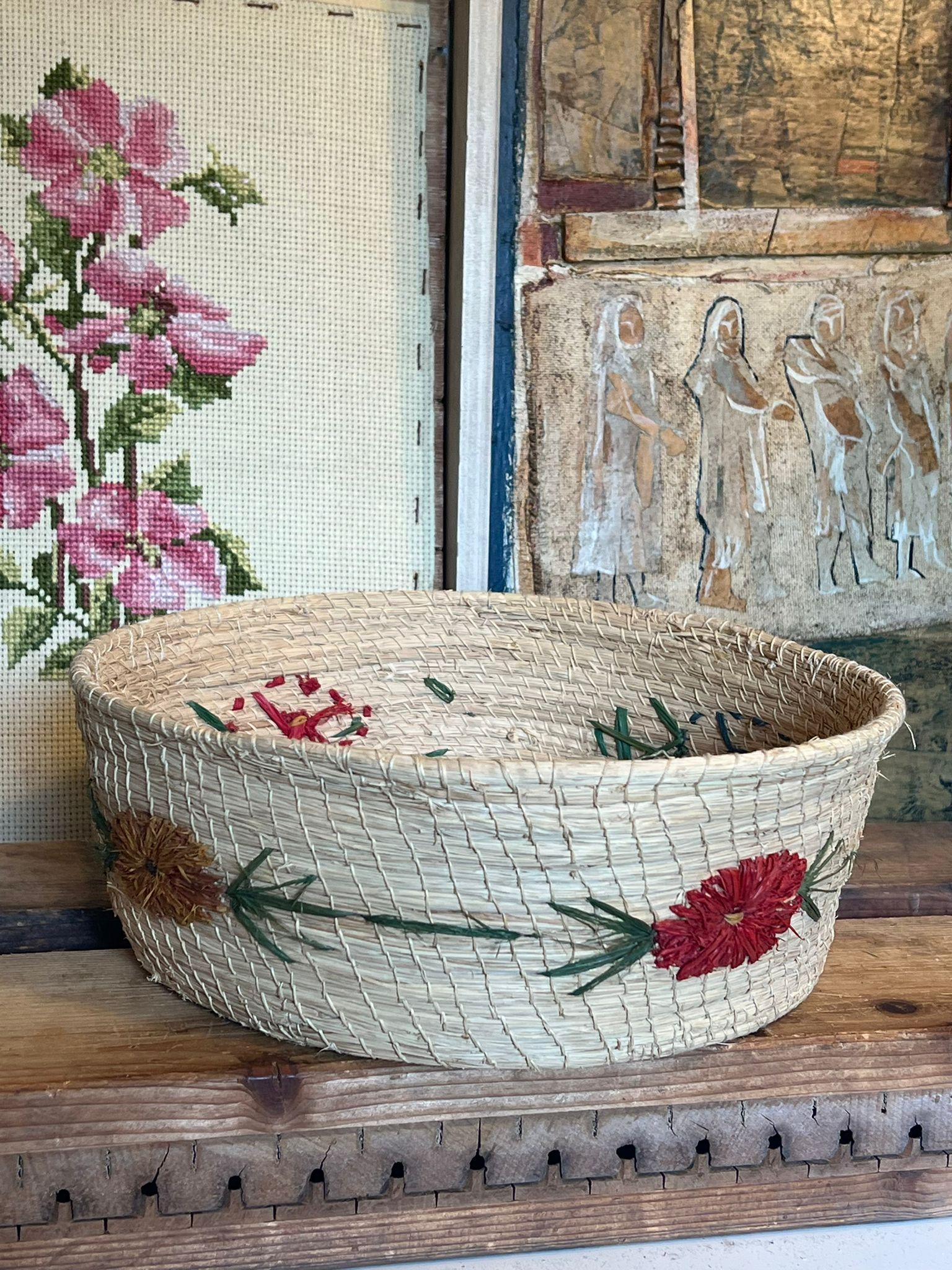 Dieser breite geflochtene Vintage-Korb oder -Schale ist mit einem Blumenmotiv bestickt. Der Ursprung ist unbekannt. Dieses Stück hat eine schöne Patina und Charakter. Vintage Condition wie abgebildet. Die Auflistung ist für den beschriebenen Artikel