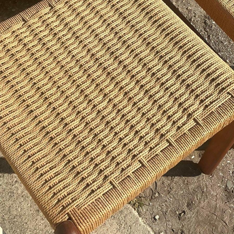 Add mid-century modern charm to your space with this set of two vintage woven rope dining chairs. Featuring sleek, minimalist frames and intricately handwoven rope seats, these chairs blend timeless design with natural textures. Their sturdy