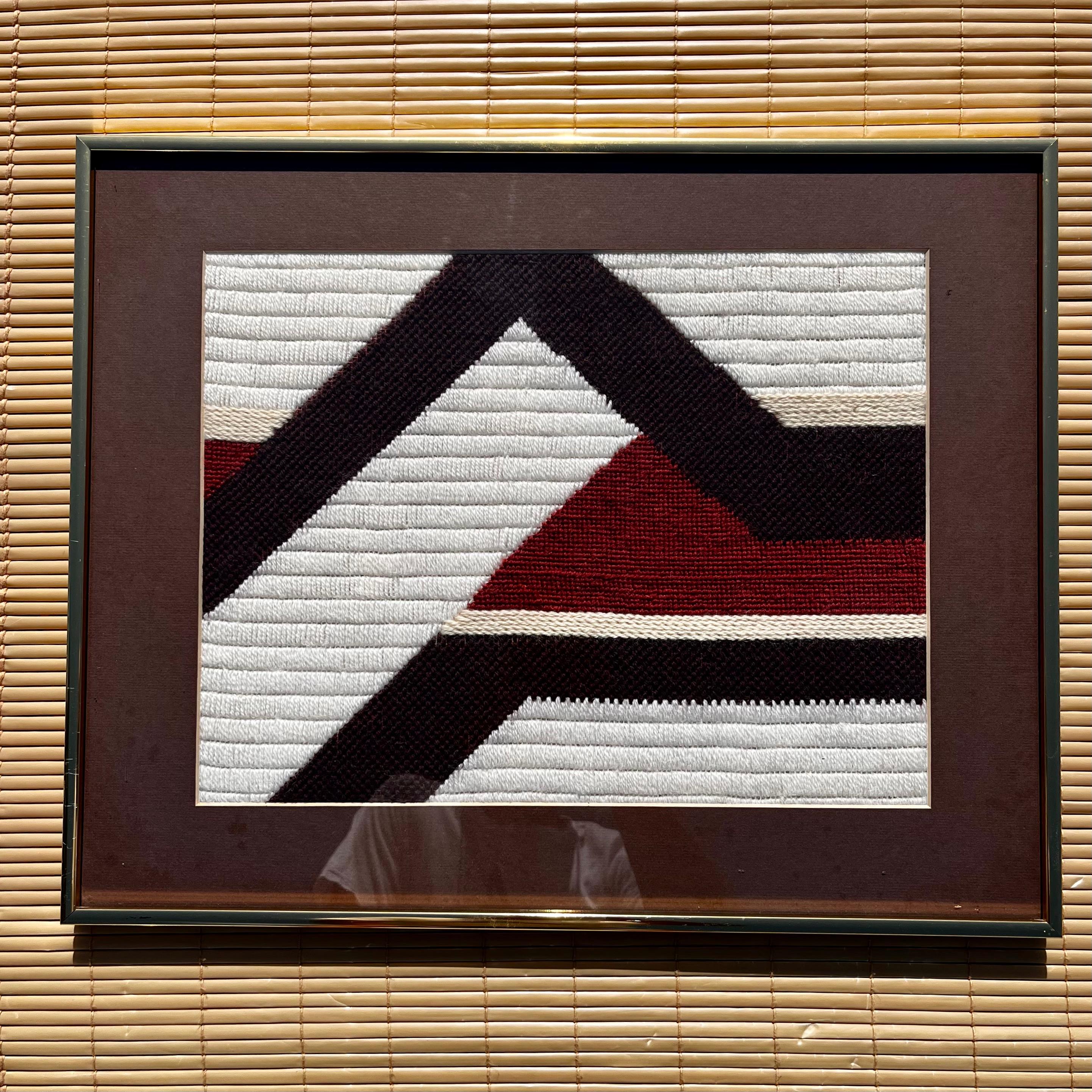 Vintage Medium Size Mid Century Modern Woven Textile Framed Abstract / Folk Wall Art. Circa 1970s
Features a handwoven abstract geometric pattern in a earth tones color palette, matted and framed with a golden anodized aluminum frame. 
In