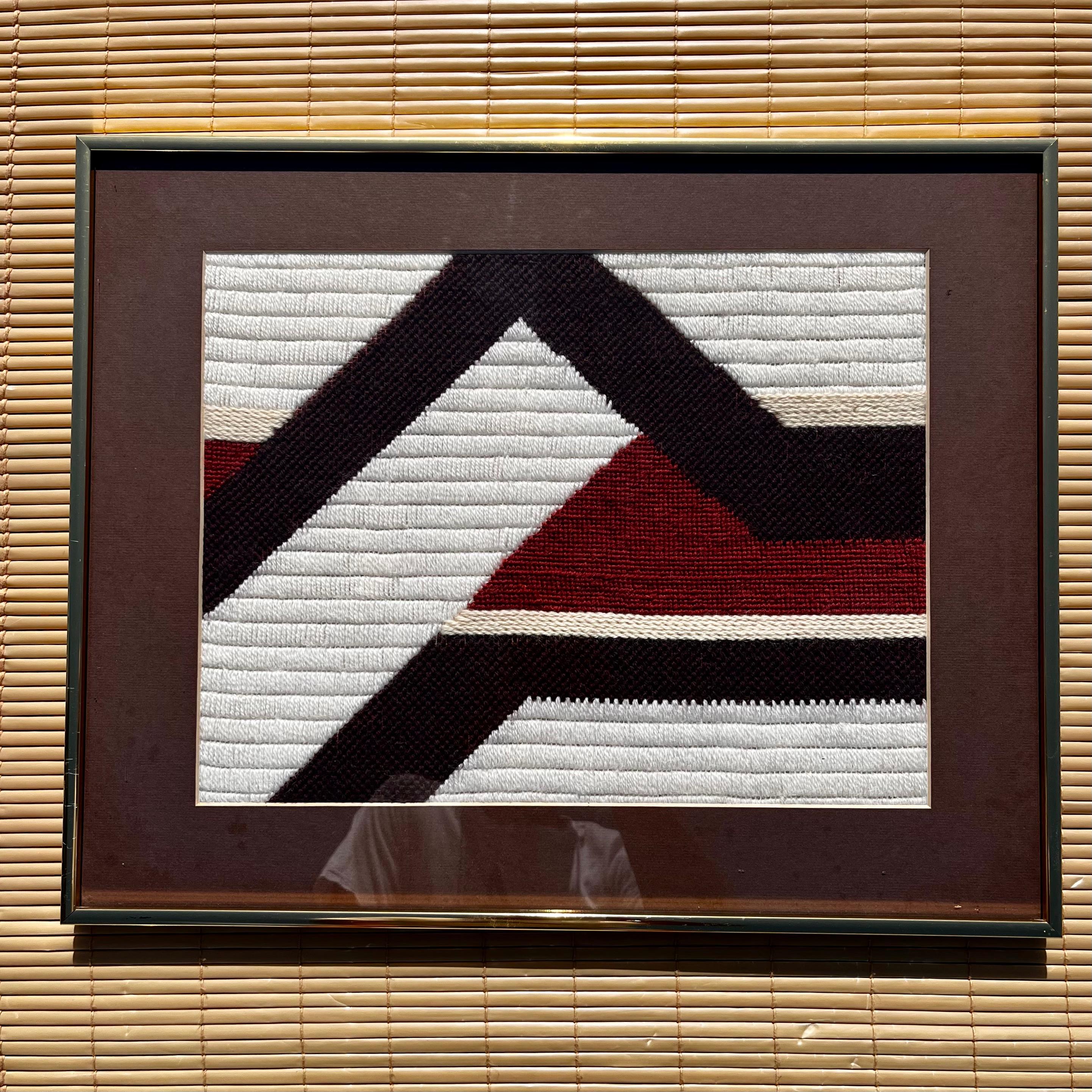 Vintage Medium Size Mid Century Modern Woven Textile Framed Abstract / Folk Wall Art. Circa 1970er Jahre
Ein handgewebtes abstraktes geometrisches Muster in Erdtönen, mattiert und gerahmt mit einem goldenen, eloxierten Aluminiumrahmen.  
In