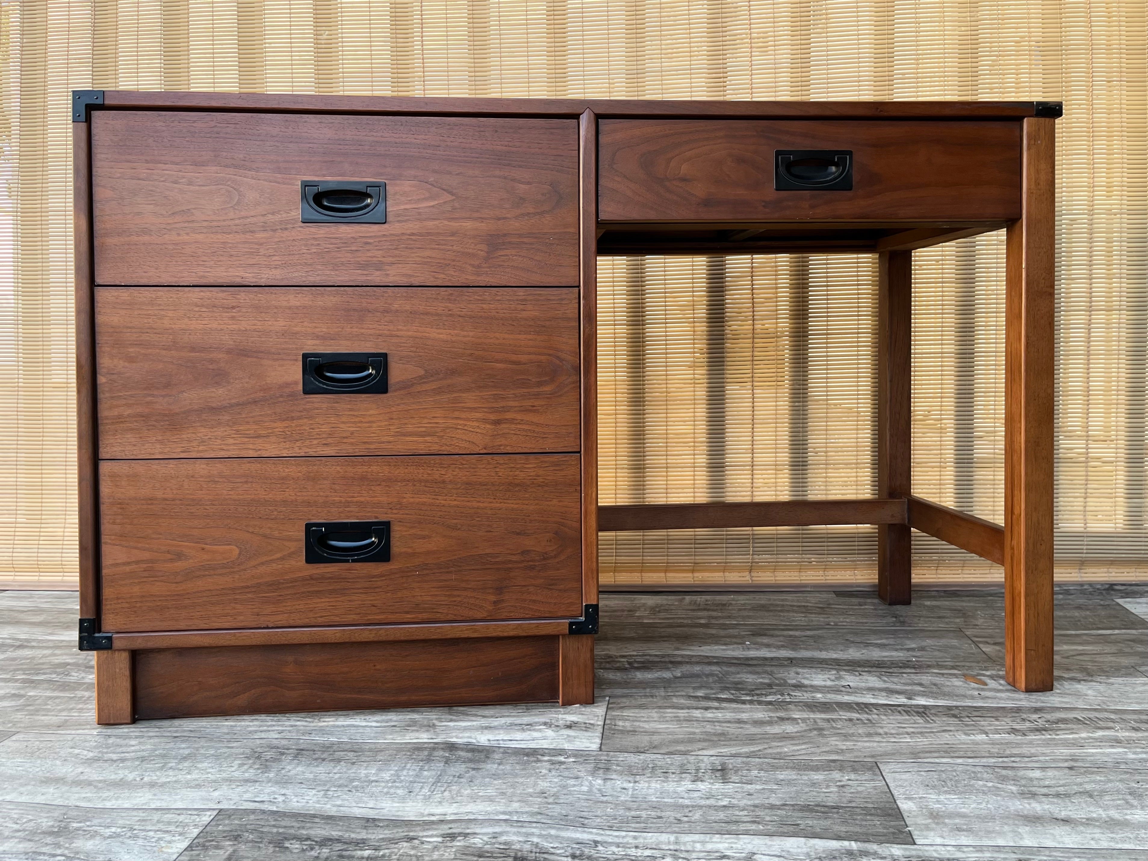 Vintage Mid-Century Modern writing desk by Drexel New Generation. Circa 1960s 
Features three spacious side drawers plus a pencil drawer with dovetail joints and a black hardware, a beautiful dark walnut wood grain, and the perfect sizing for small