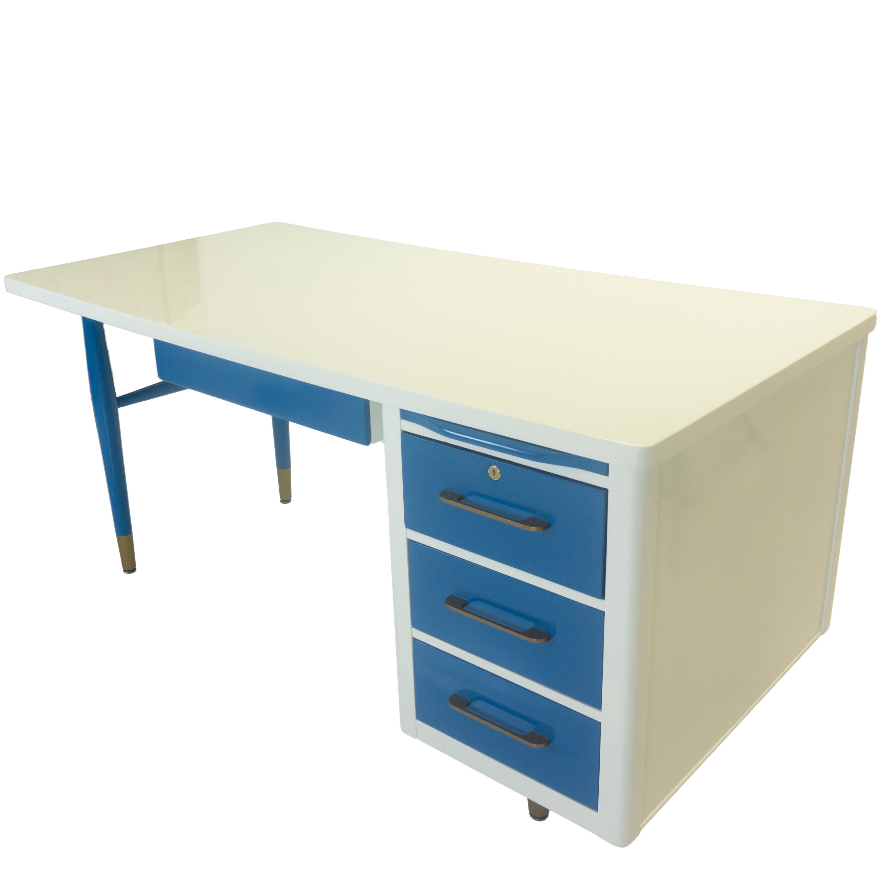 Ce bureau vintage de style Mid-Century Modern a été entièrement rénové et rafraîchi pour être aussi beau que neuf. Sa structure en bois est peinte en blanc avec des tiroirs bleus et des accents de quincaillerie en bronze. Chaque tiroir dispose de