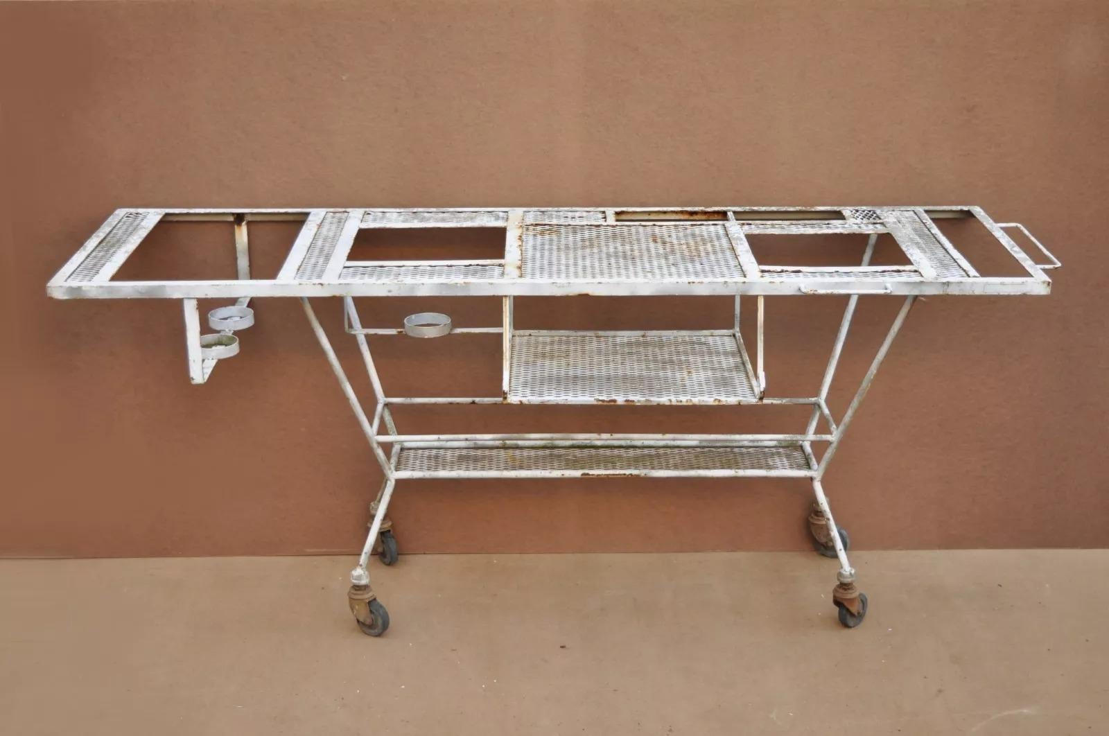 Vintage Wrought Iron Industrial Steampunk Rolling Bar Cart BBQ Pit Table. Item features various compartments, rolling wheels, mesh surfaces, side handle, wrought iron construction, great style and form, original use is unknown but great to