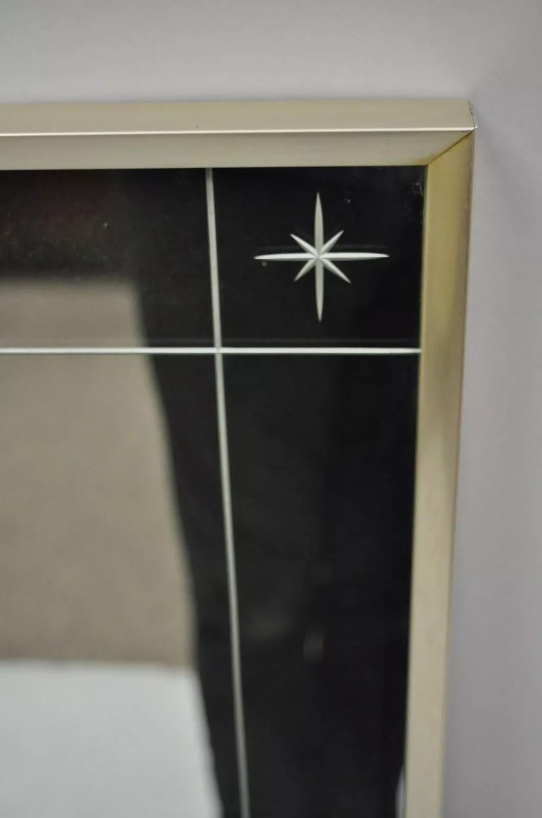 Vintage Mid Century Modernist Etched Star Frame Wall Mirror with Silver Metal Frame. L'article présente quatre étoiles en verre gravé dans les coins, une bordure gravée, des crochets à l'arrière pour une suspension verticale ou horizontale, un cadre