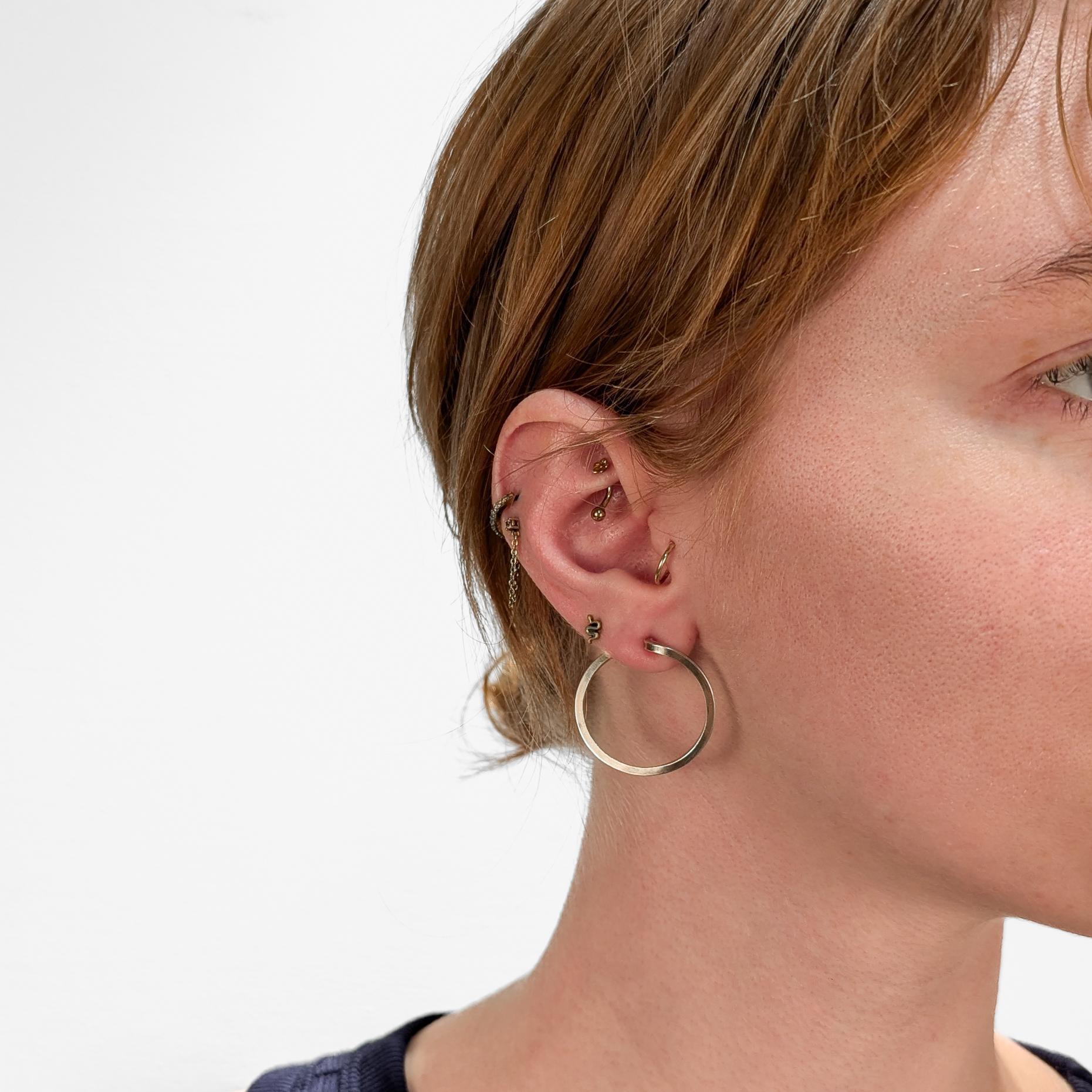 A pair of fine Mid-Century Modern silver hoop earrings.

In sterling silver with a gilt finish.

By Paul Lobel. Lobel was a Romanian-born and New York based jeweler, designer, illustrator who was an influential Modernist and beloved figure in the