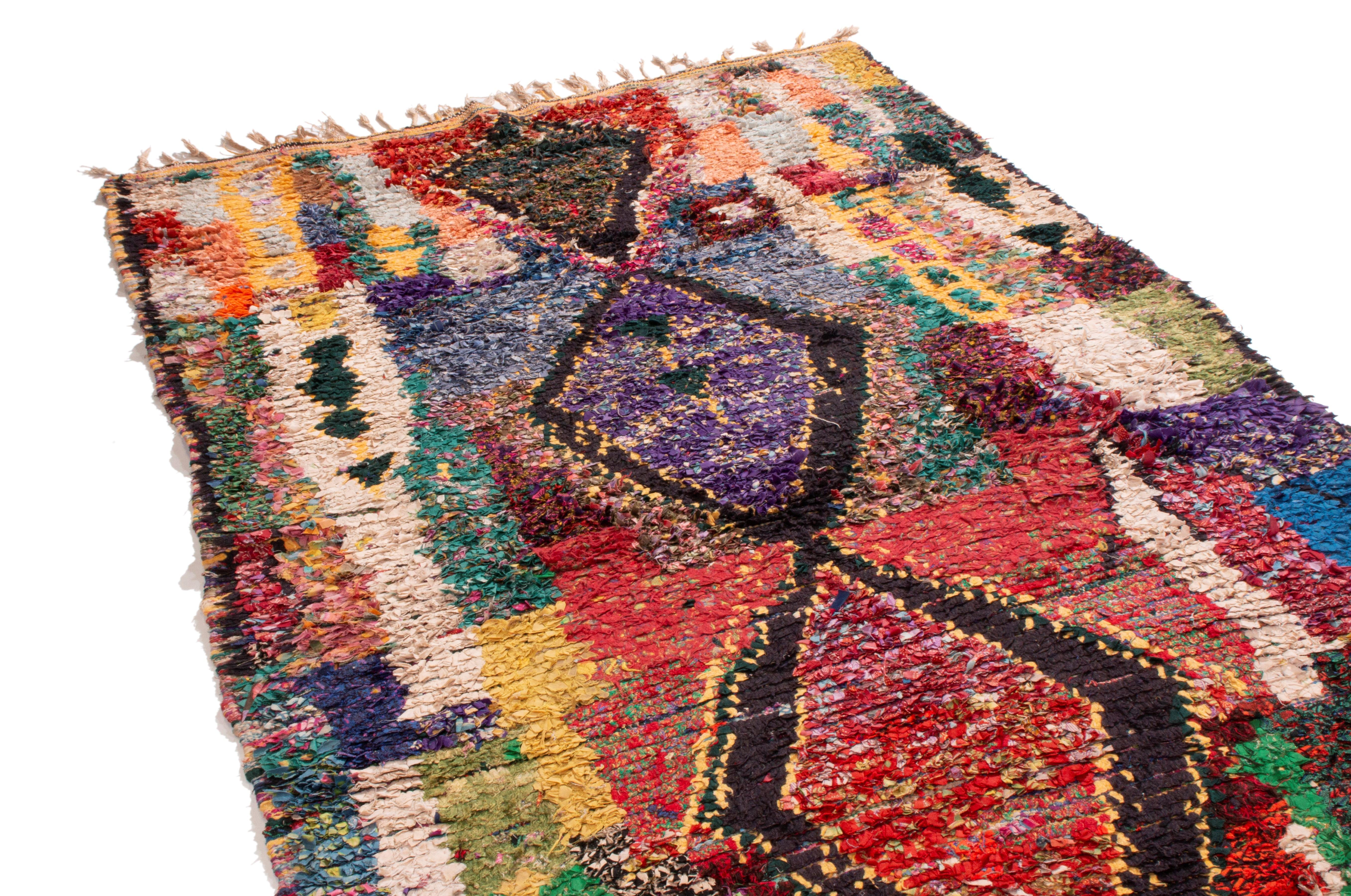 Proveniente dal Marocco nel 1950, questo tappeto berbero marocchino vintage della metà del secolo scorso utilizza un approccio transitorio al simbolismo matriarcale e patriarcale nel suo design di campo. Annodato a mano in lana di alta qualità,