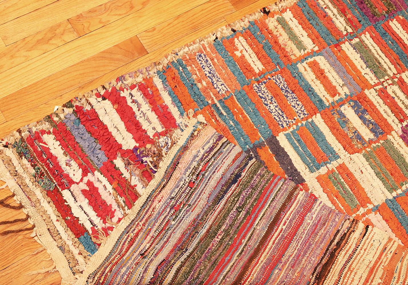 A beautiful long and narrow size, mid-20th century, vintage Moroccan rag rug. Size: 3 ft 10 in x 8 ft 8 in (1.17 m x 2.64 m)

This alluring vintage Moroccan rug features an exceptionally modern visage decorated with compartmental motifs rendered in