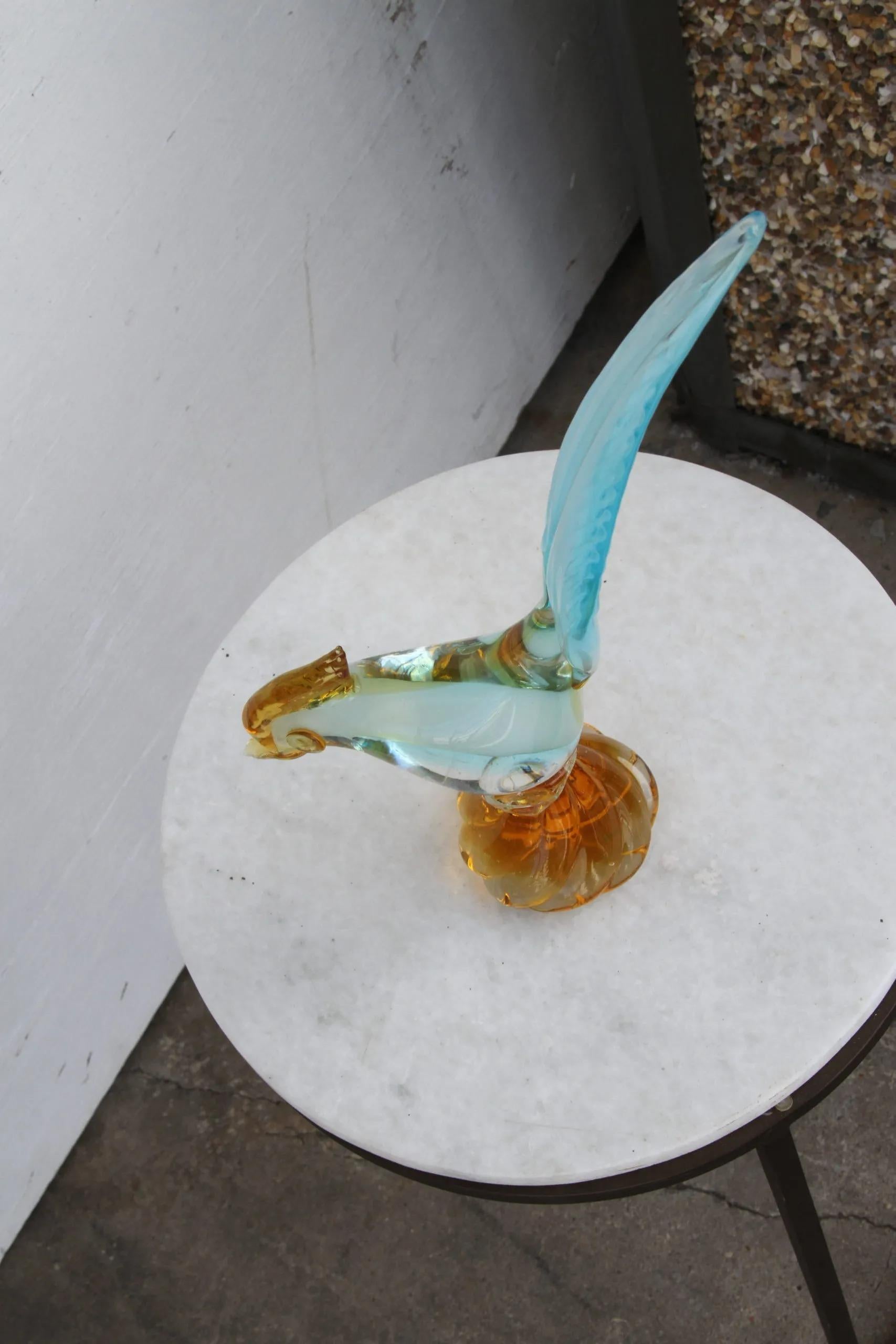 Vintage mid-century Murano glass roadrunner.

Mid-century Italian Murano hand-blown bird in aquamarine blue and amber. Stands 12.5 H.


