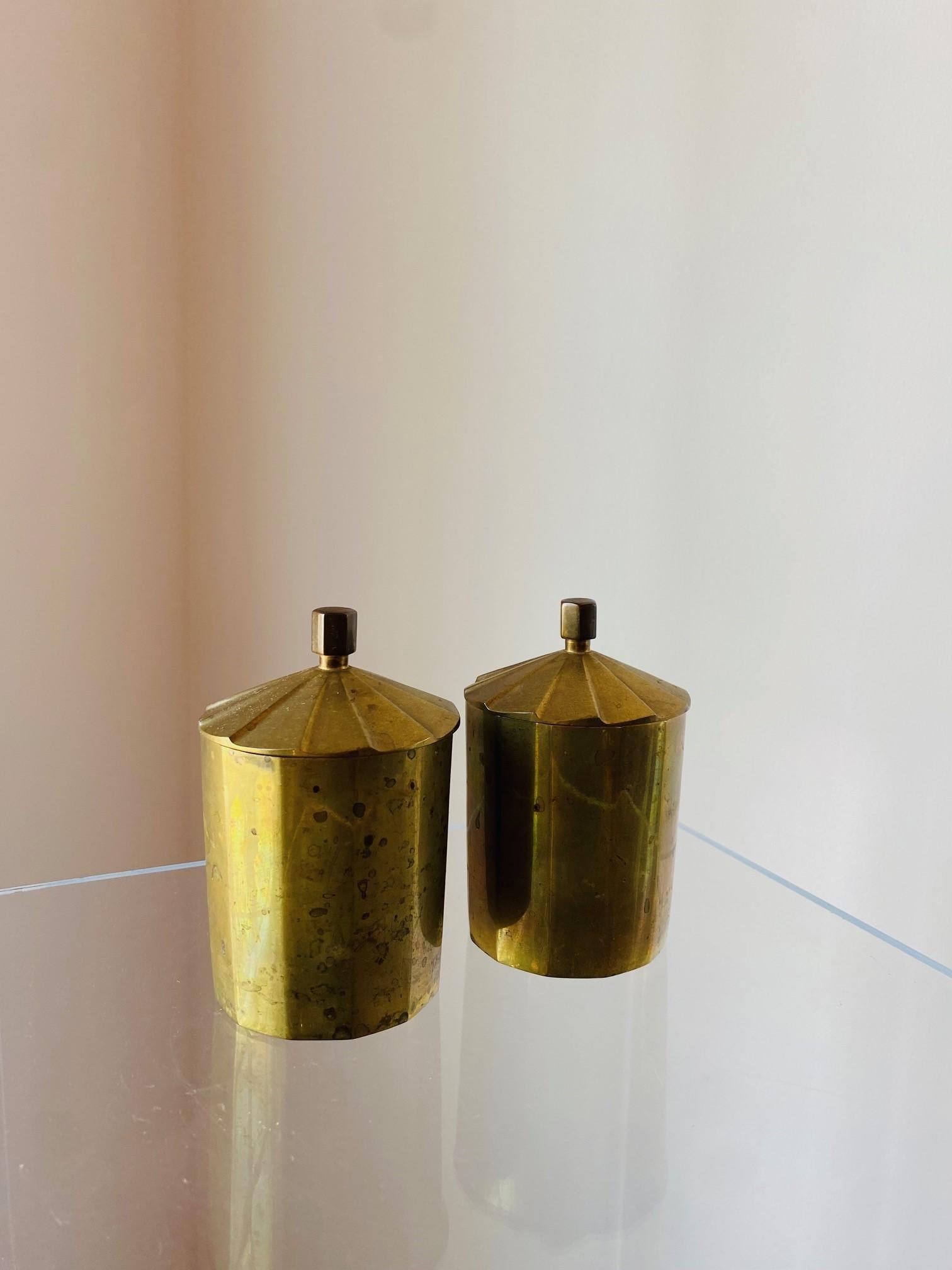 Incredibly rich and substantial pair of brass canisters.  Each of these canisters is beautifully crafted.  The patinated surface adds to their rich and substantial style.  Ideal pieces that will add bohemian glamour to your decor.  Each simple