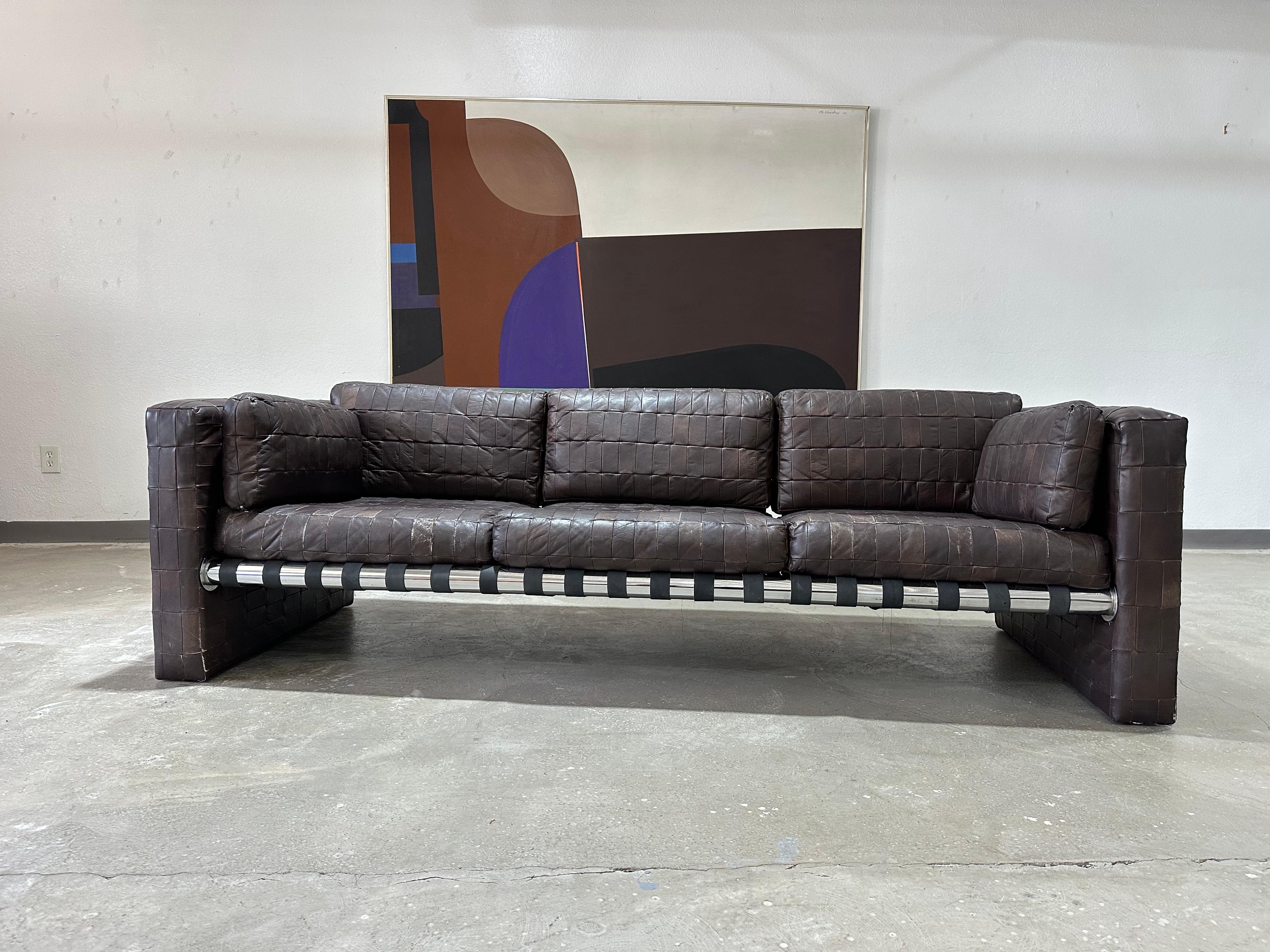 Vintage 1970’s Patchwork Brown Leather Sofa with tubular chrome frame and exterior fittings with black strap sling system. Very much in the style of Swiss maker De Sede, maker unknown. Perfectly worn in and Patinated, an exceptionally attractive