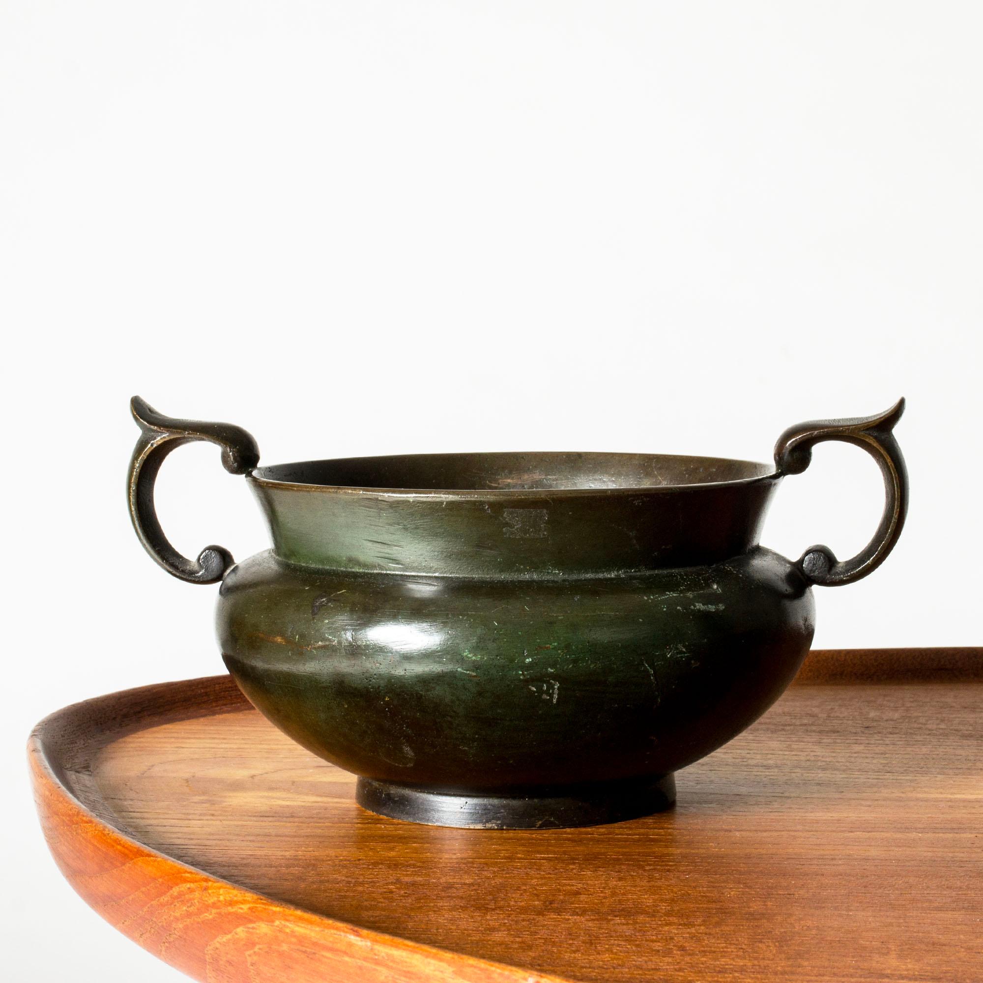 Elegante ciotola o fioriera decorativa in bronzo degli anni '30 di GAB, dalla forma massiccia con manici elborati. Patinato a olio con profonde sfumature di verde.

GAB è stata fondata a Stoccolma nel 1867 e per oltre un secolo ha esercitato