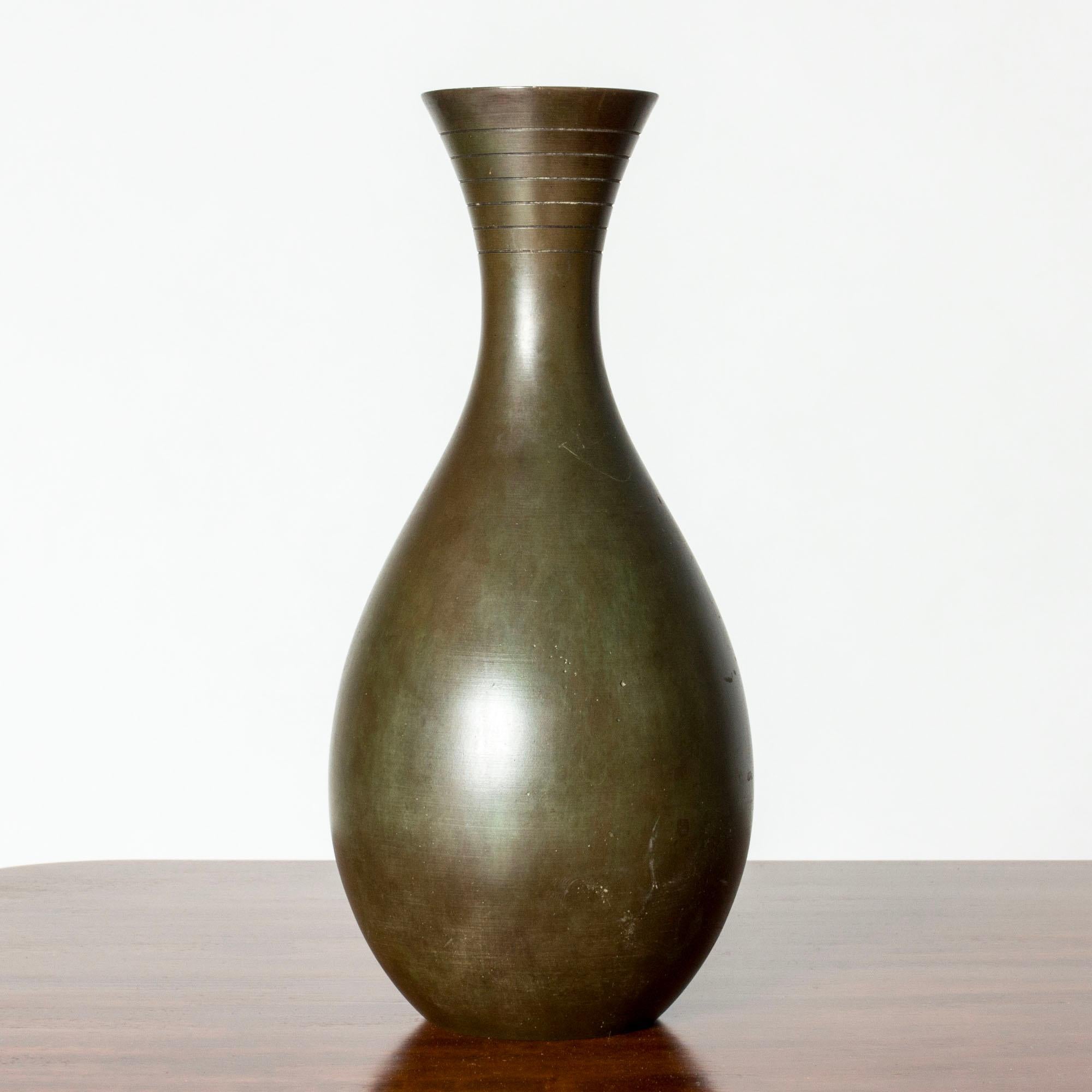 Elegante vaso in bronzo di GAB, patinato verde scuro in varie sfumature. Forma classica con strisce decorative intorno al bordo.

GAB è stata fondata a Stoccolma nel 1867 e per oltre un secolo ha esercitato un'importante influenza sulla scena