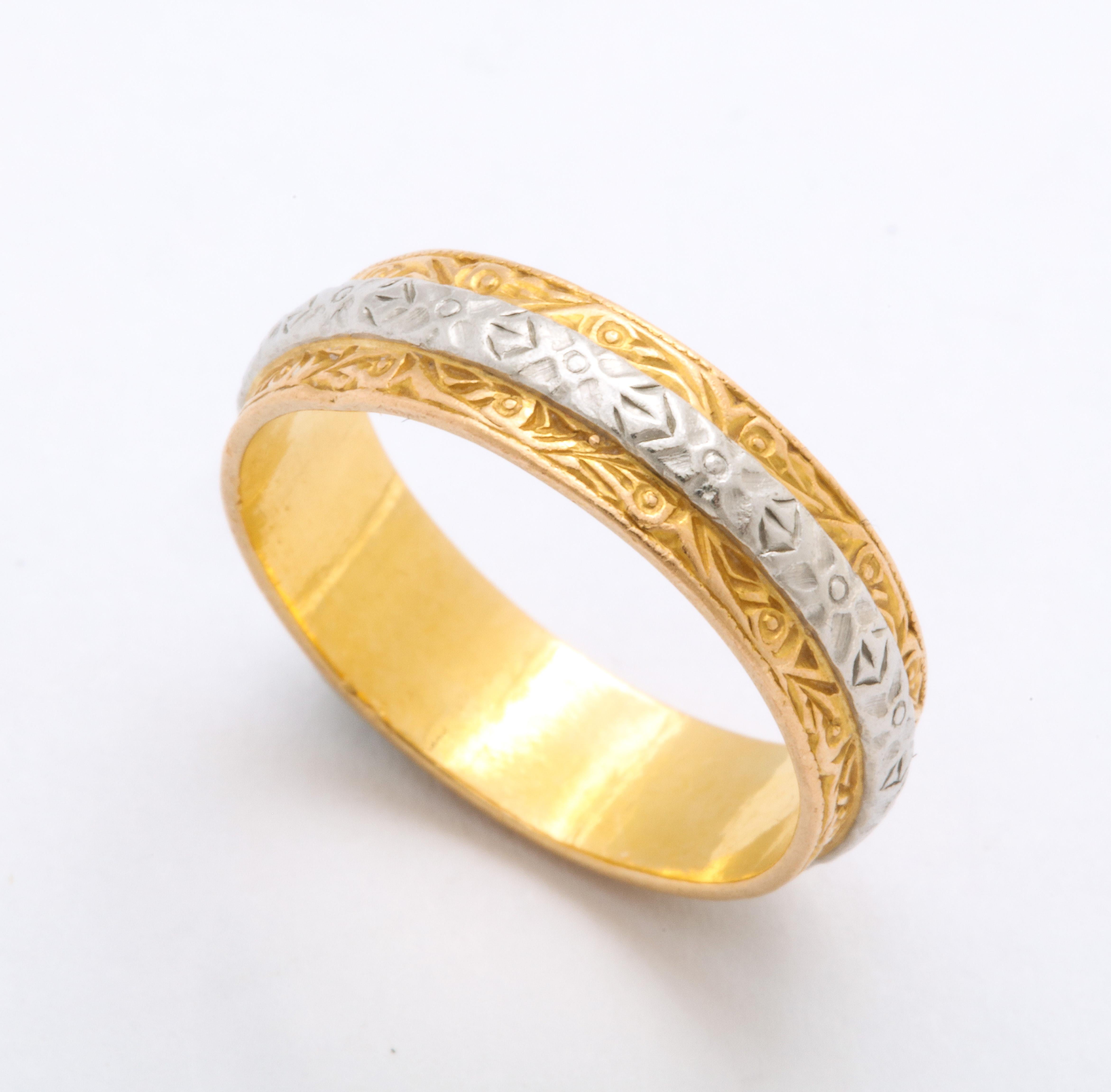 In chased 22 Kt gold with a platinum band around the center, this ring, by Charles Green and Son is as elegant, simple, and comfortable on the finger. The gold is adorned with scrolls and foliate details. The ring is a delight worn alone or perfect